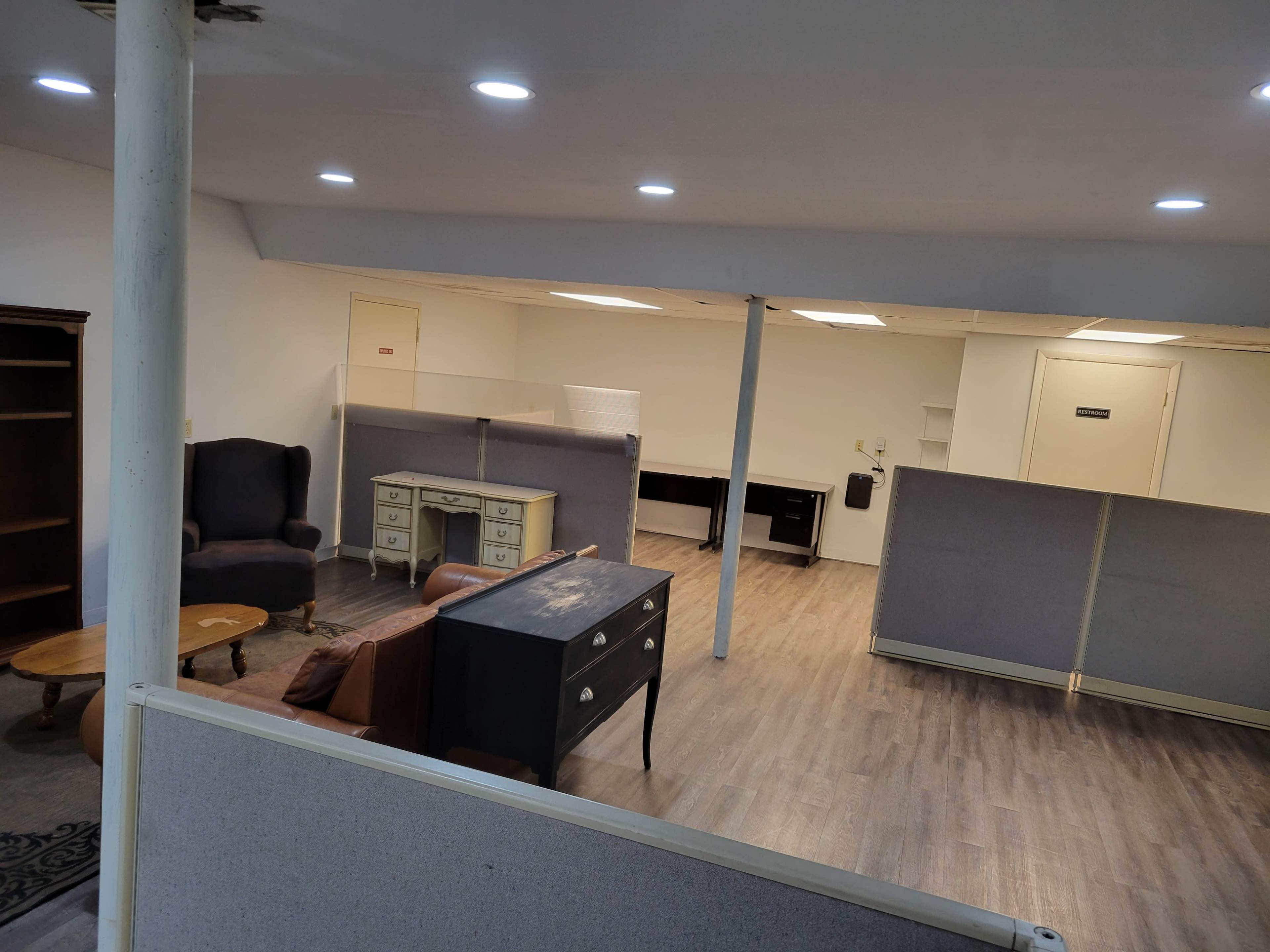 An empty office space featuring several desks, chairs, and room dividers.