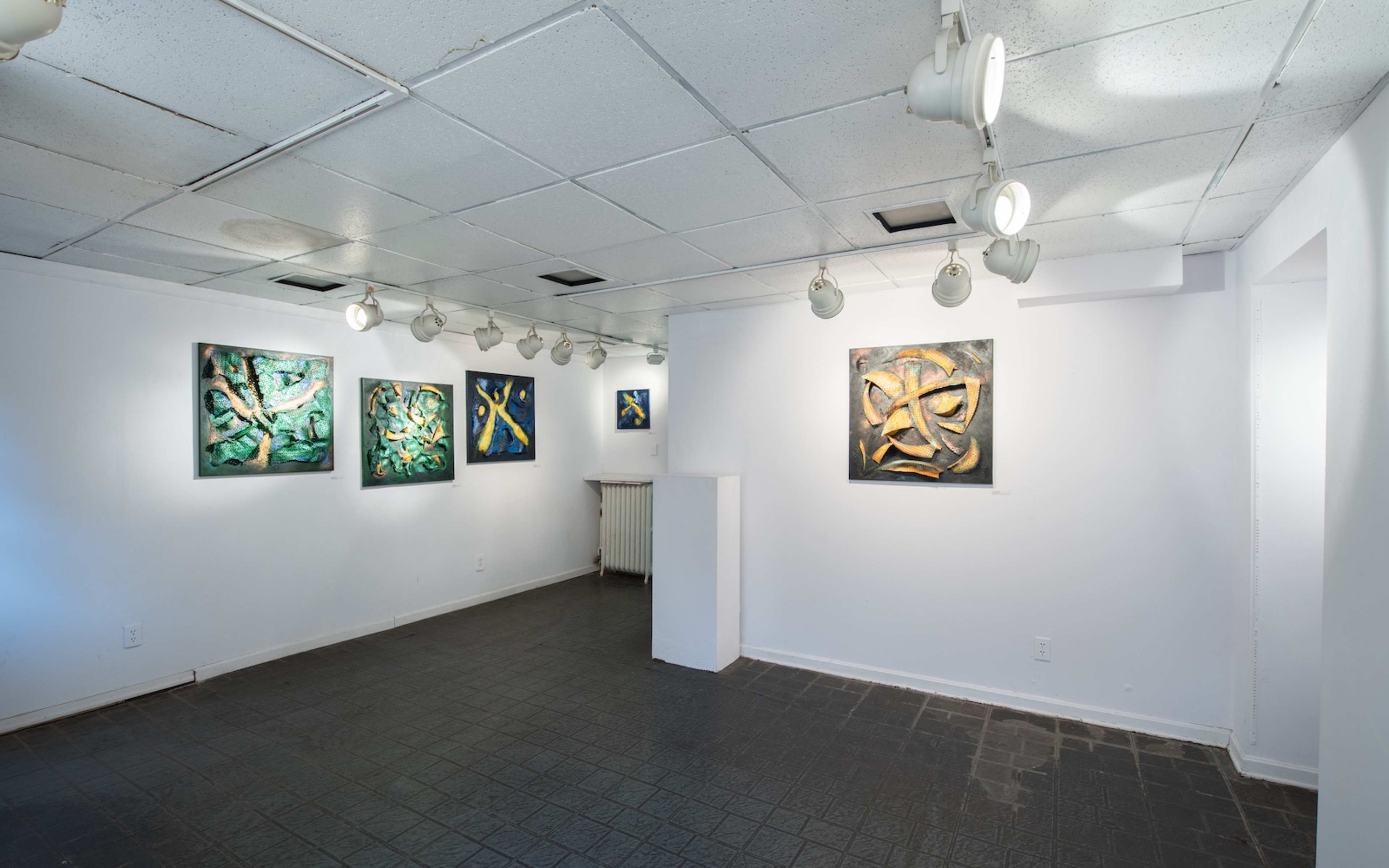 An art gallery with several paintings displayed on the walls and spotlights illuminating the artworks.
