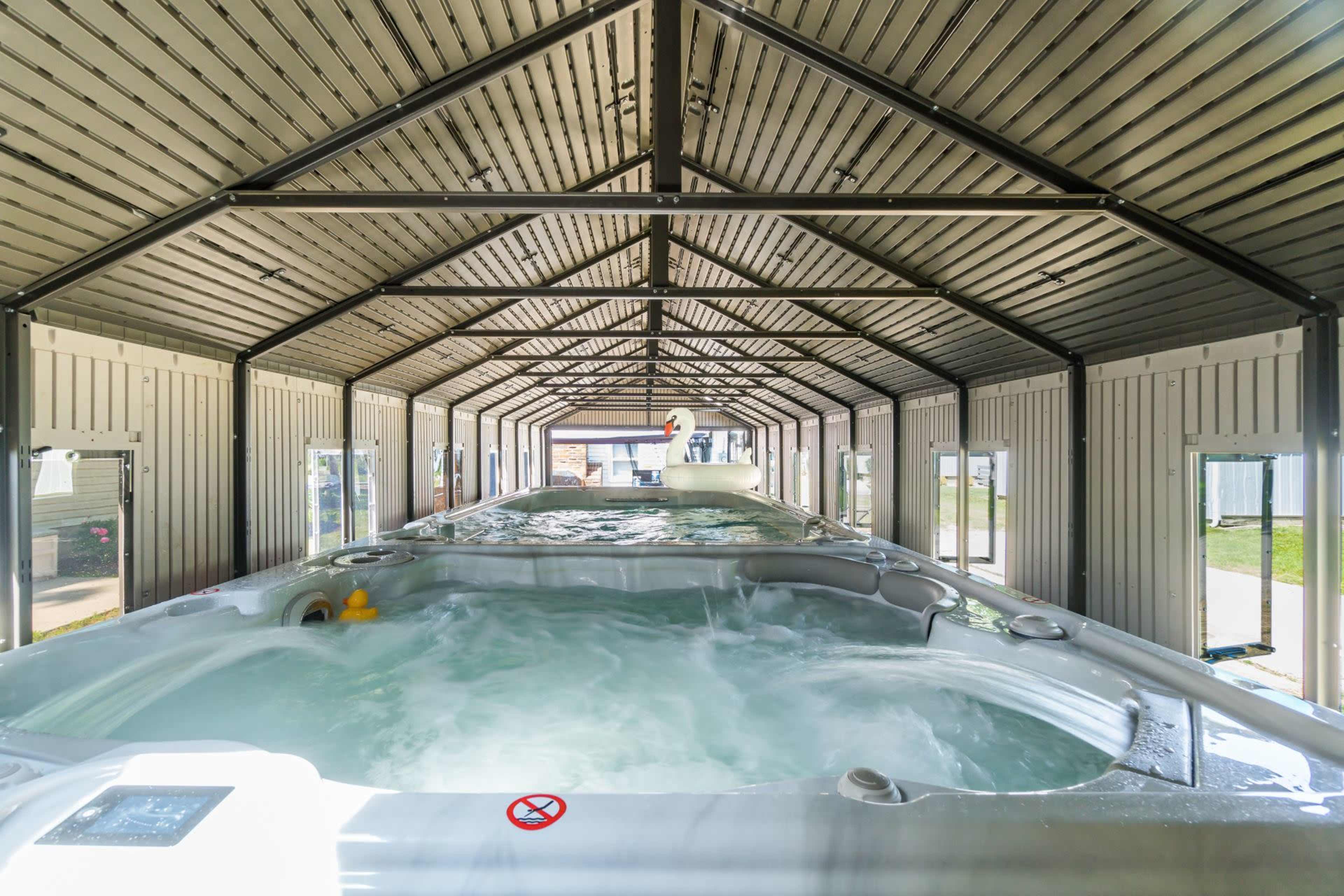 A spacious indoor area containing multiple hot tubs surrounded by large windows.