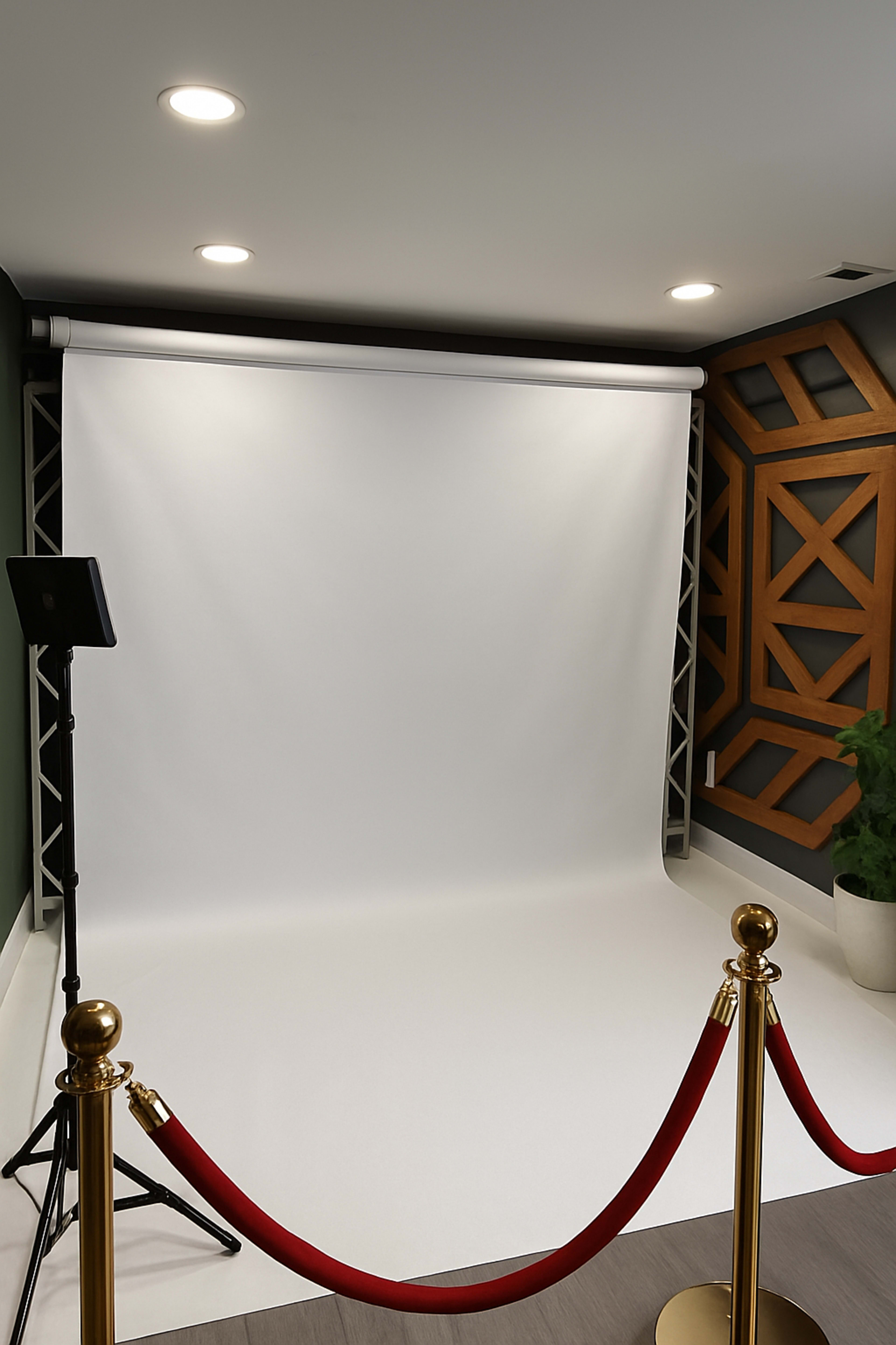 The scene features a photo studio setup with a white backdrop, a tripod microphone stand, and a red rope barrier in front of it.
