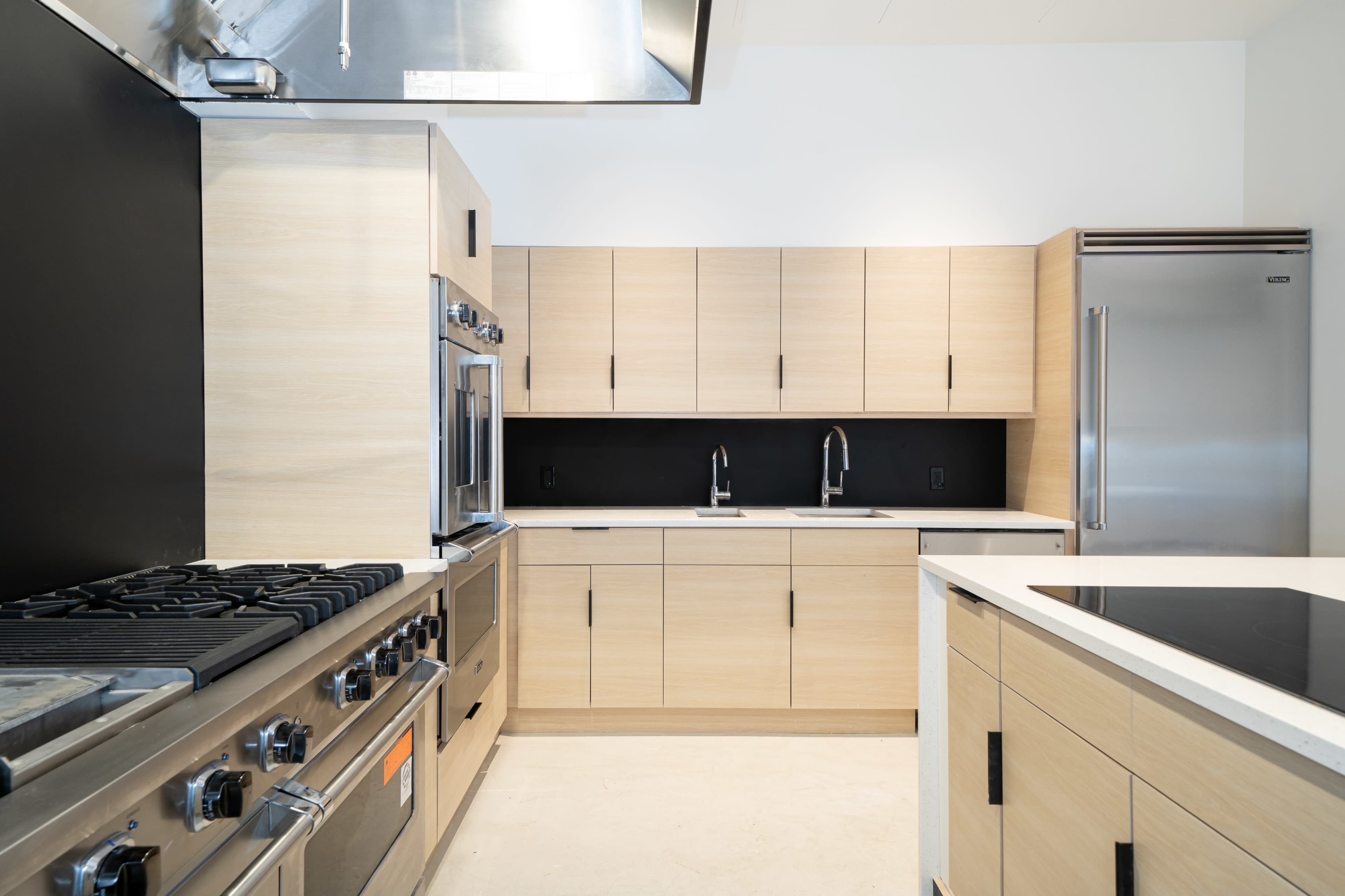 A modern kitchen featuring sleek wooden cabinetry, stainless steel appliances, and a central island with an induction cooktop.