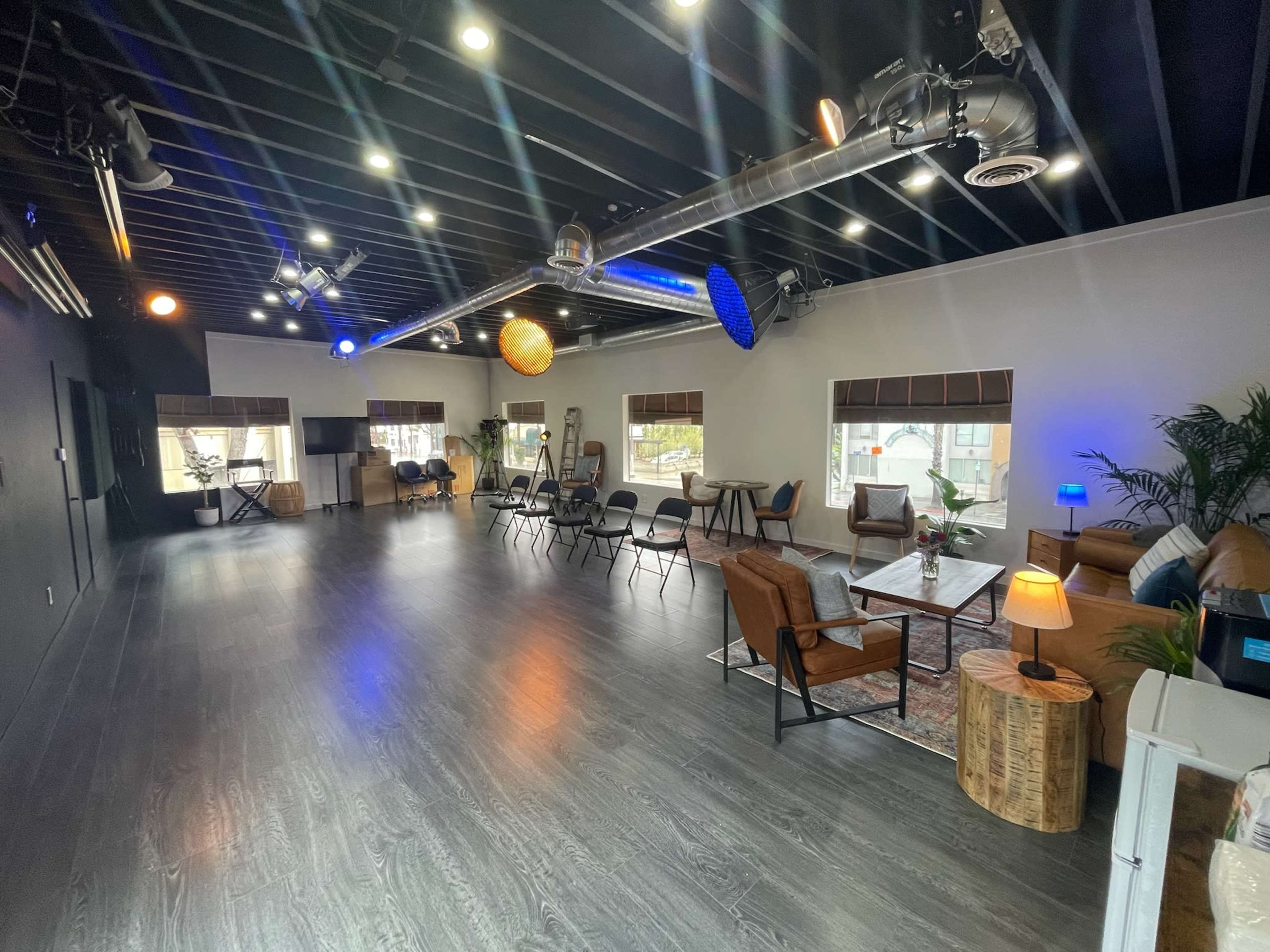 A modern, spacious interior with seating arrangements and decorative light fixtures.