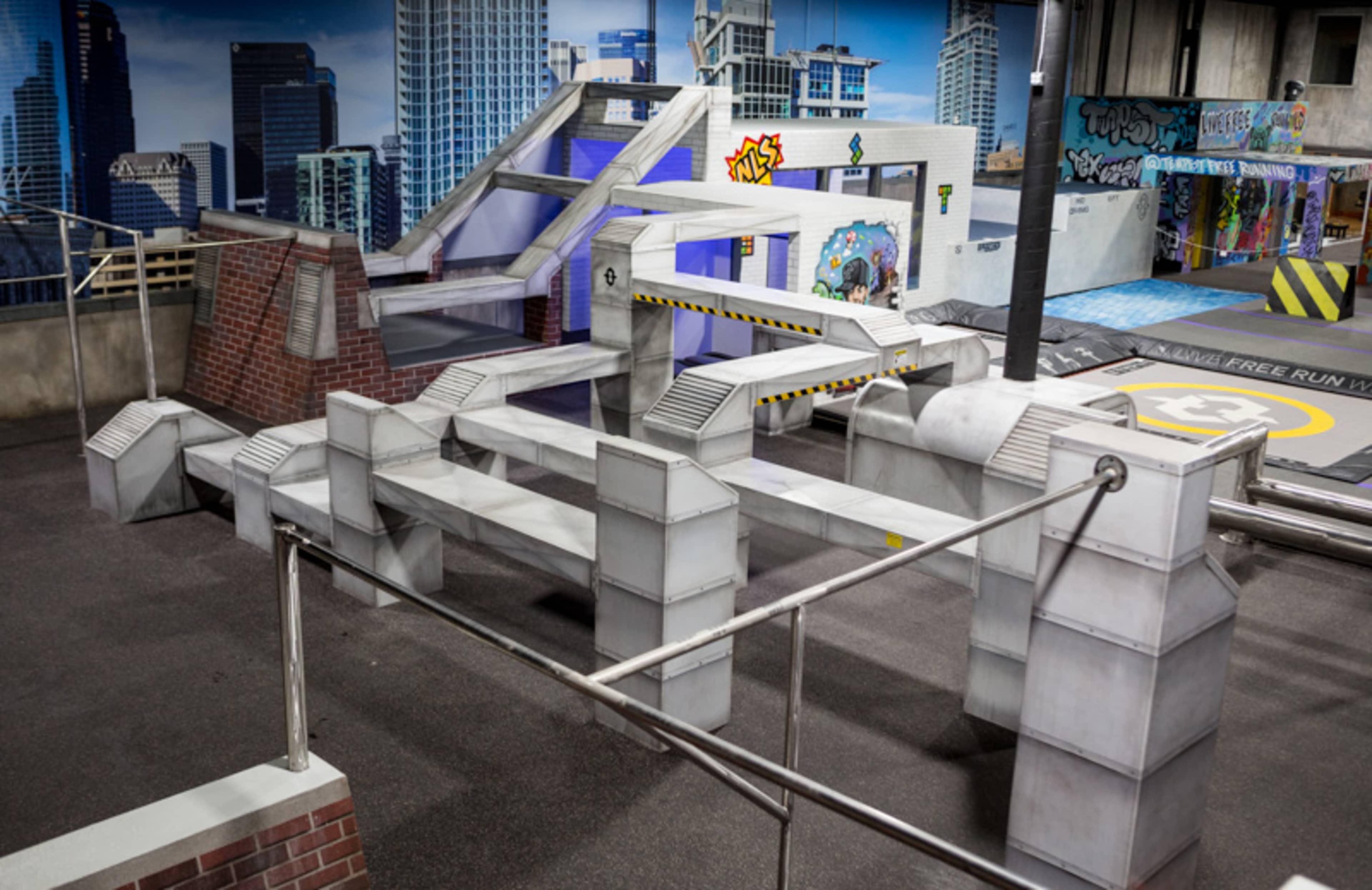 The image shows a geometric parkour training area with various levels and obstacles designed for urban-style movement.