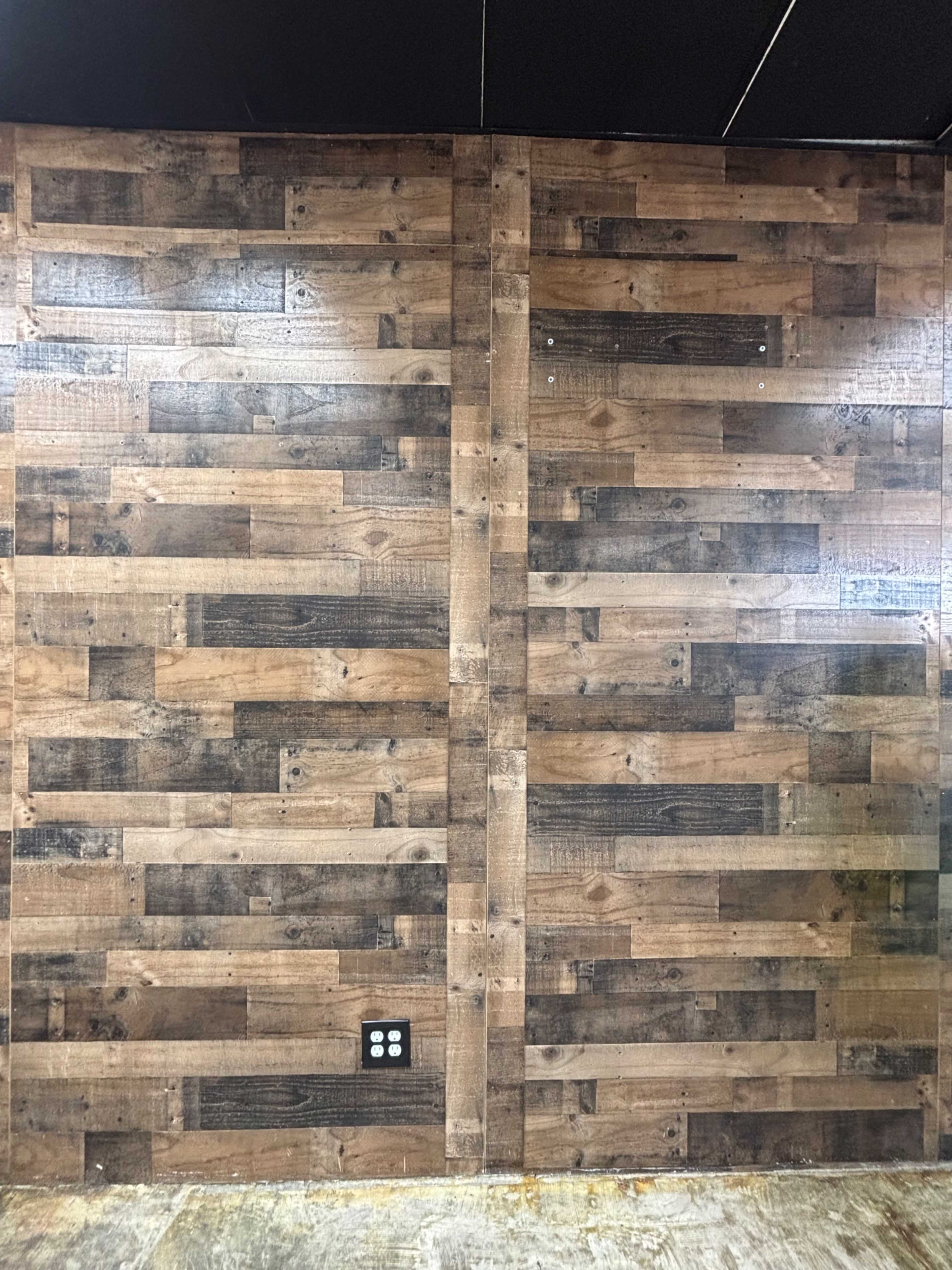 The image shows a wooden wall with a pattern of alternating horizontal planks in various shades of brown.