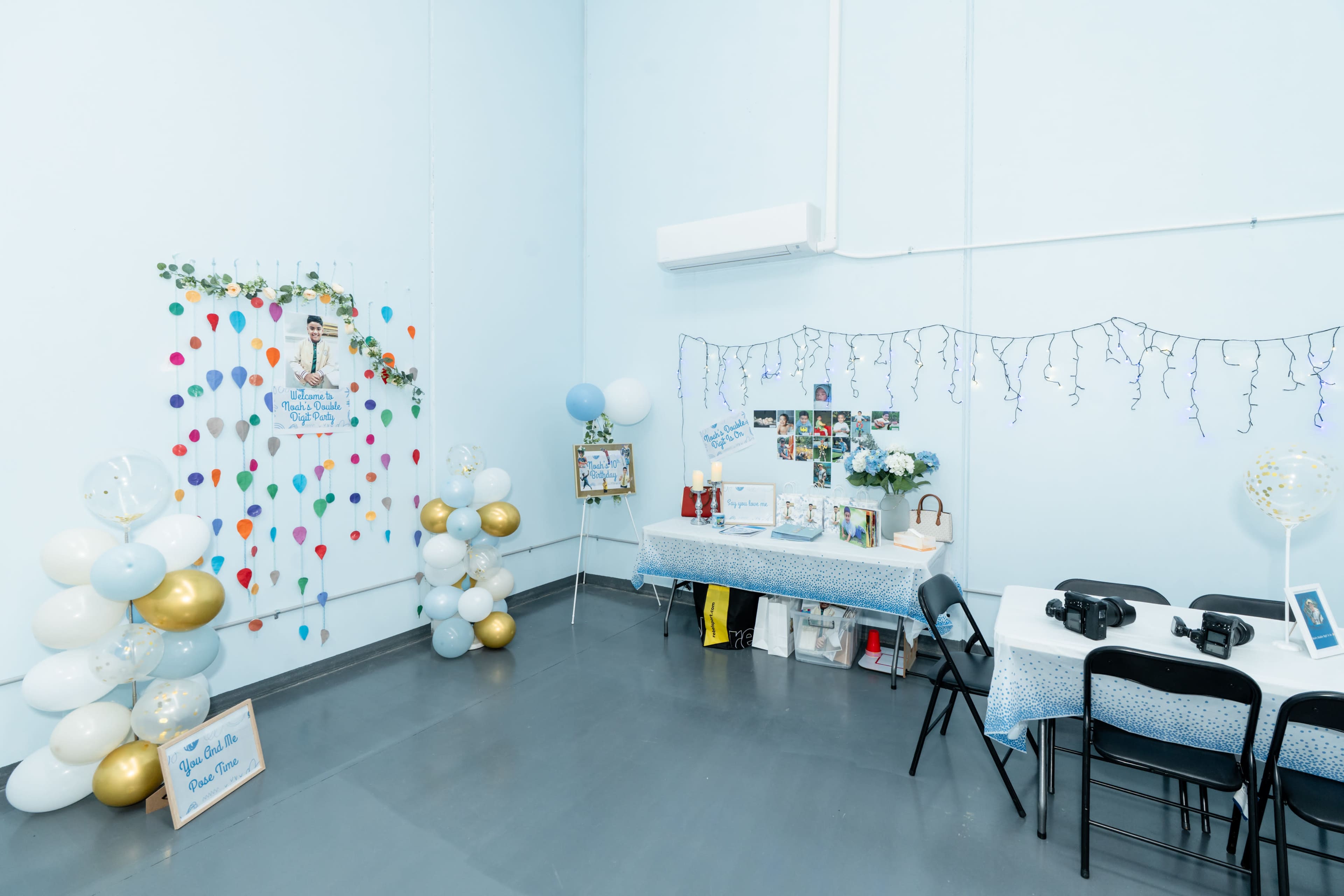 The scene shows a decorated room with a table set up for an event, adorned with balloons and festive decorations along the walls.