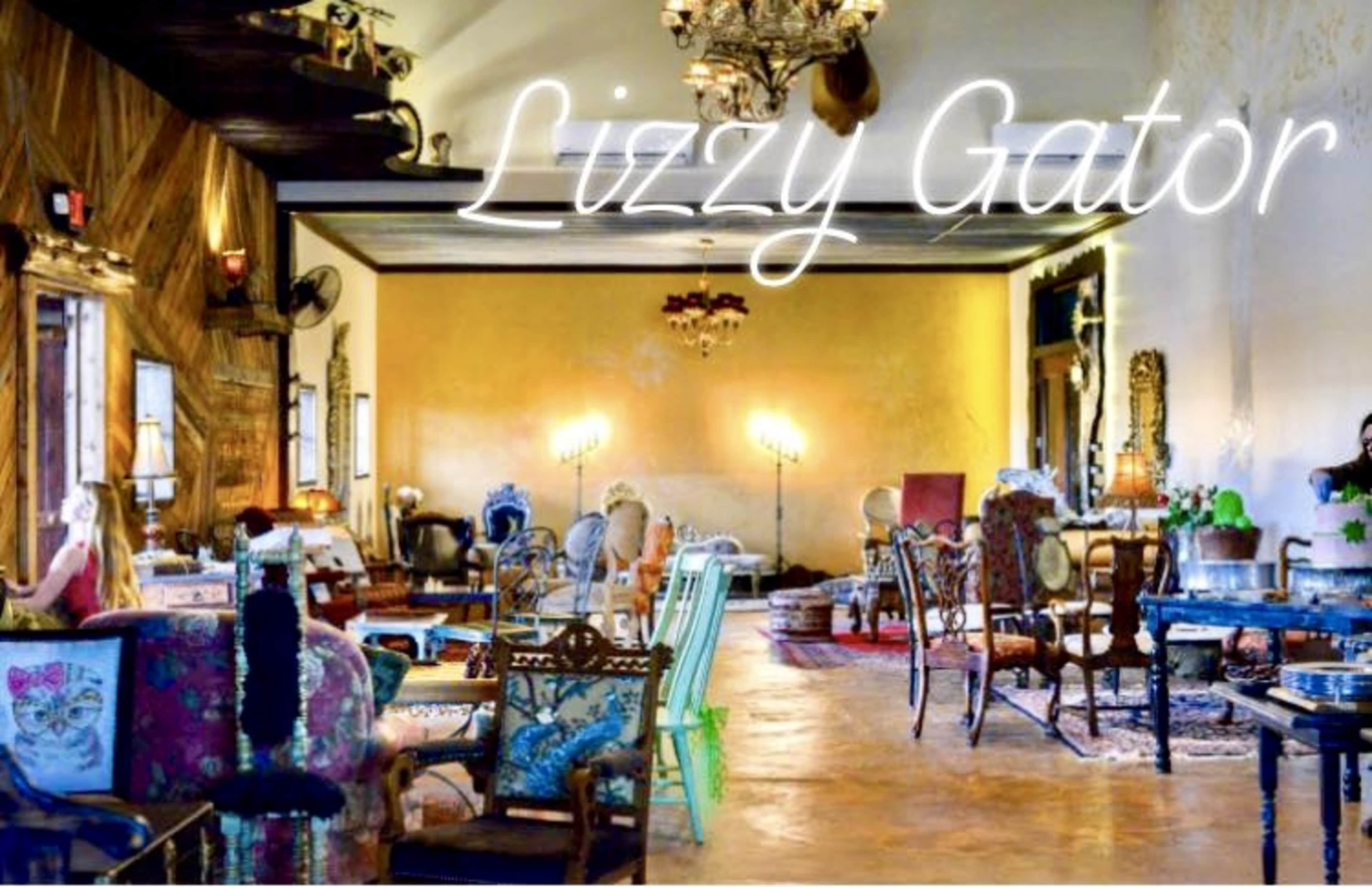 The image shows a stylish interior space filled with various upholstered chairs and a few decorative furnishings, illuminated by ambient lighting.