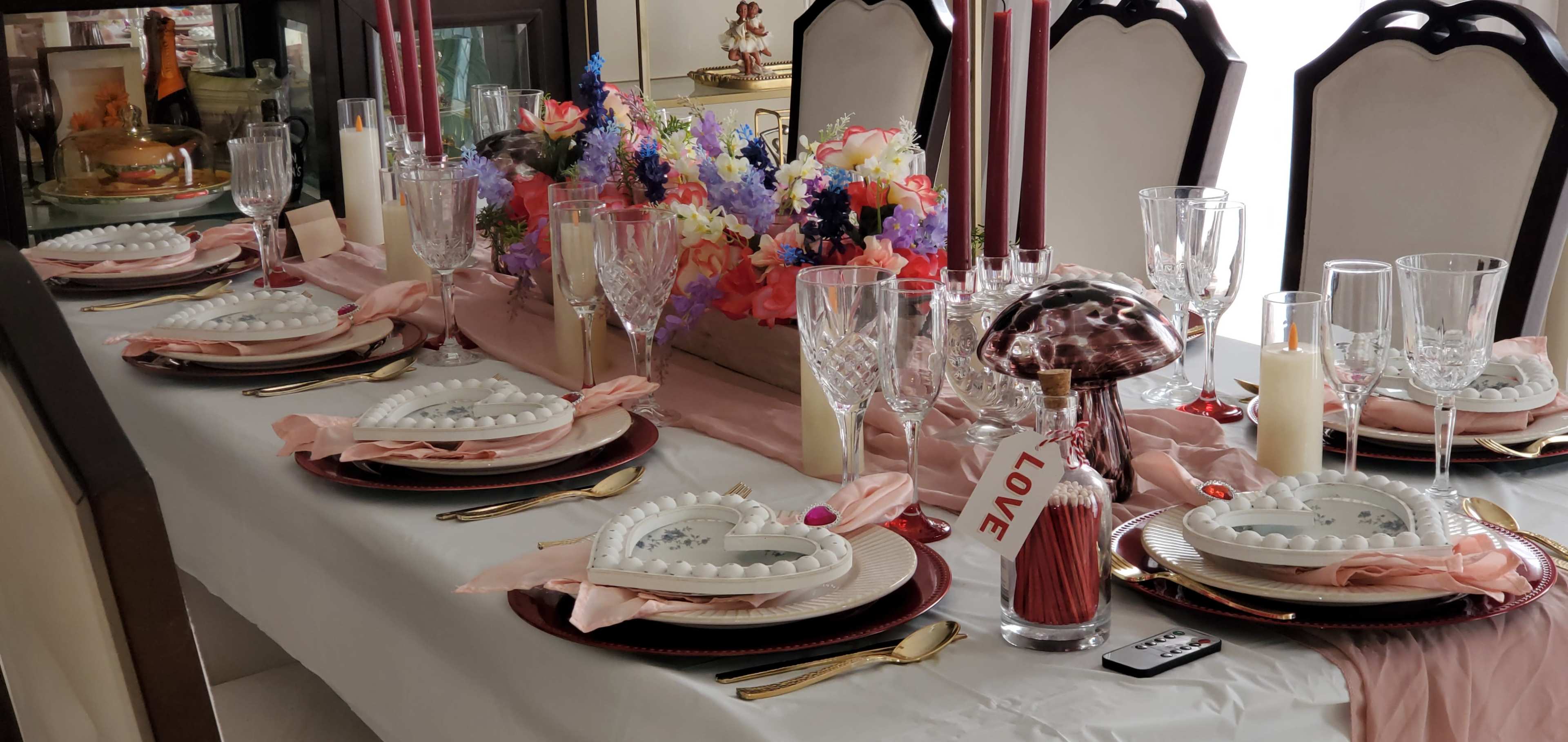 Love's Enchanted Oasis." This romantic dinner table is a masterfully crafted haven, where love and magic entwine. The soft glow of candles, the gentle dance of flowers, and the warm, inviting ambiance all converge to create an intimate and enchanting atmosphere, perfect for a dreamy Valentine's Day celebration. Image in LaSalle, Buffalo, NY