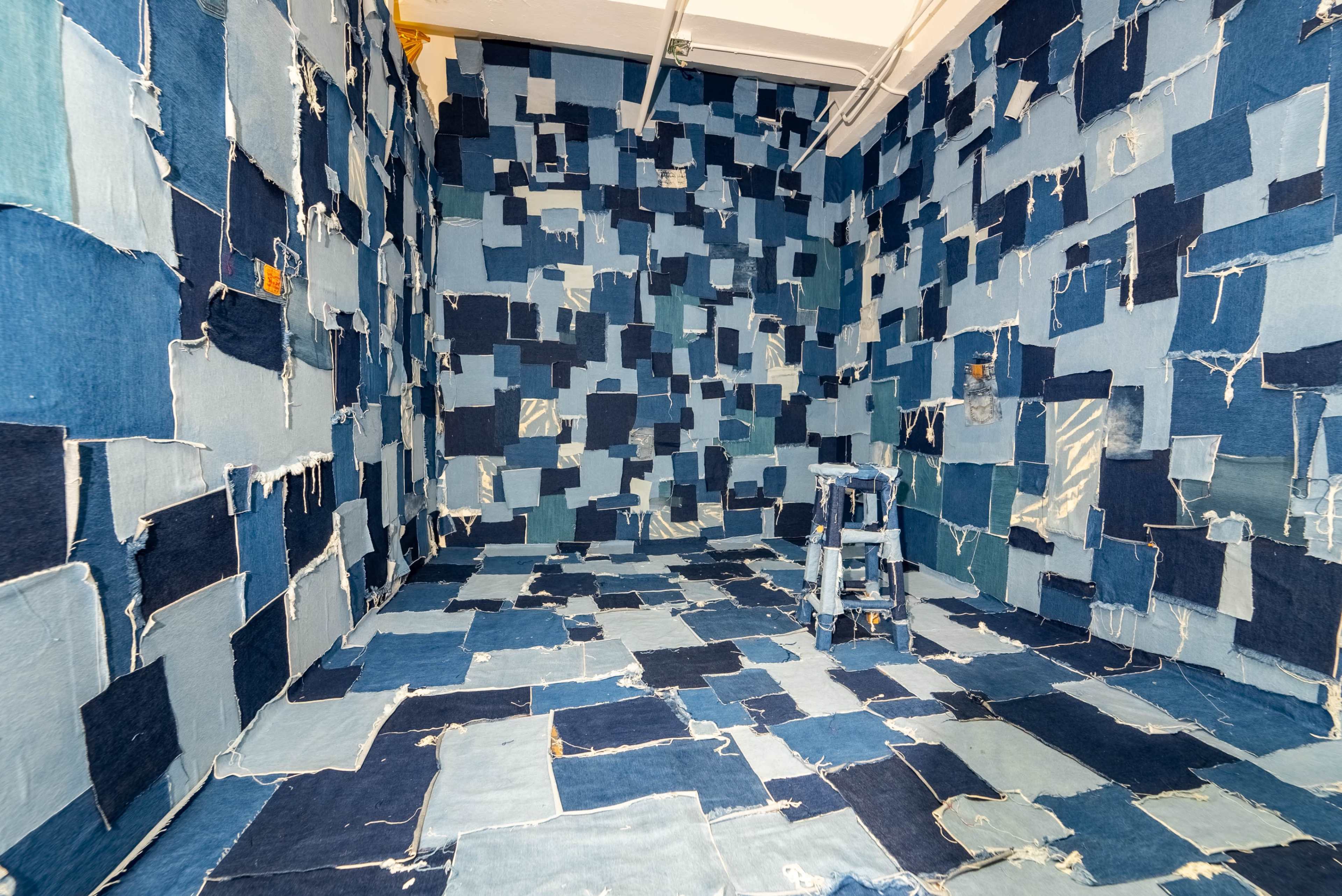 The scene features a room with walls and floors covered in varying patches of blue denim fabric.