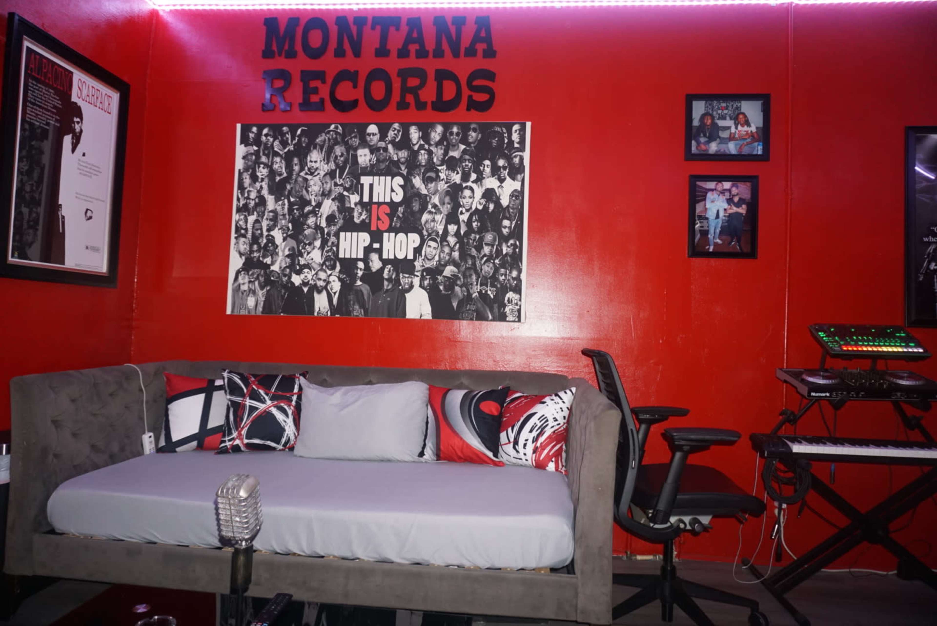 The image features a recording studio room with red walls, a couch, and music equipment, along with framed pictures and a large poster that reads "THIS IS HIP-HOP."