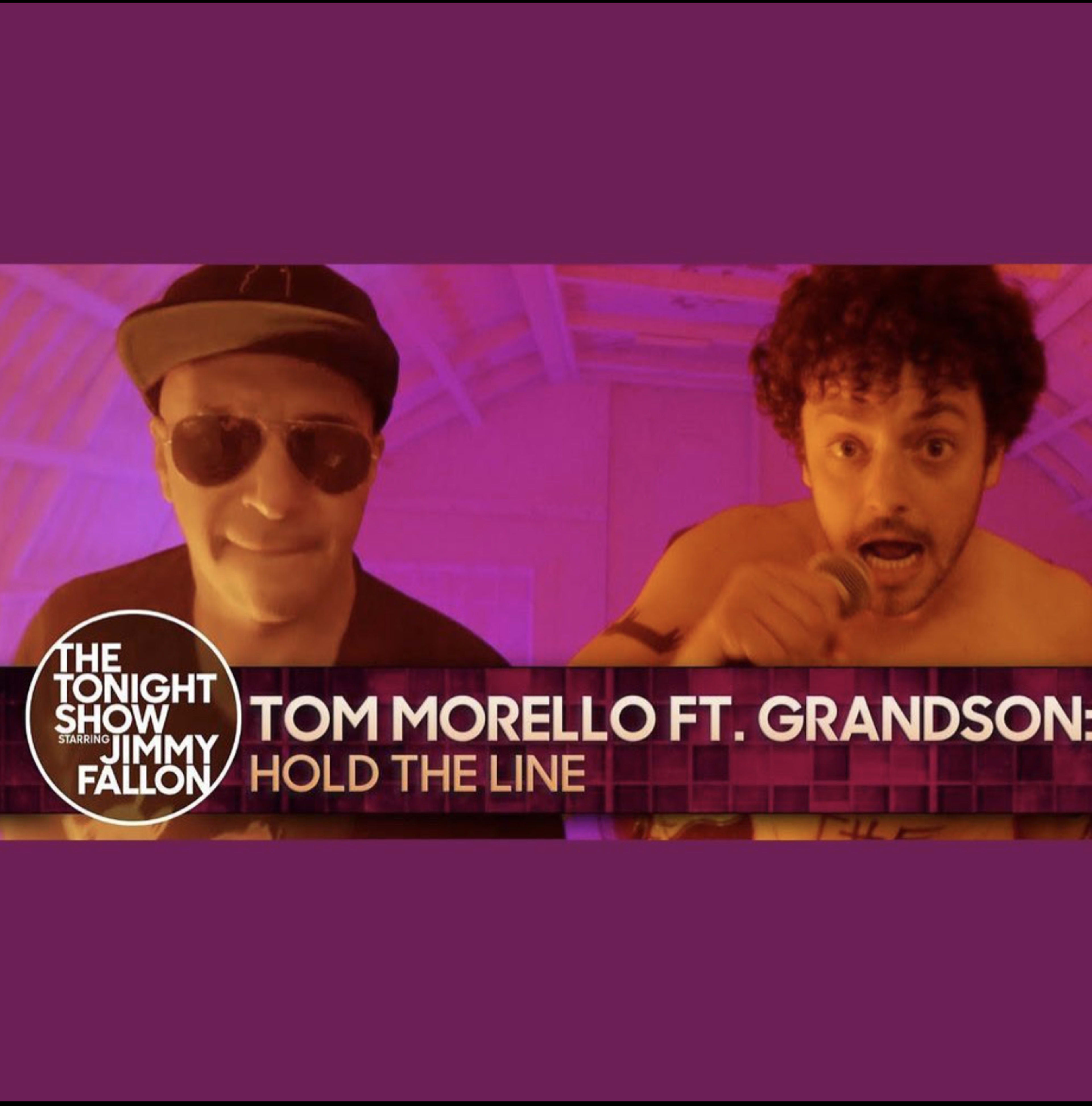 Two performers, one wearing sunglasses and a cap and the other holding a microphone, with text indicating they are performing "Hold the Line" on "The Tonight Show Starring Jimmy Fallon."