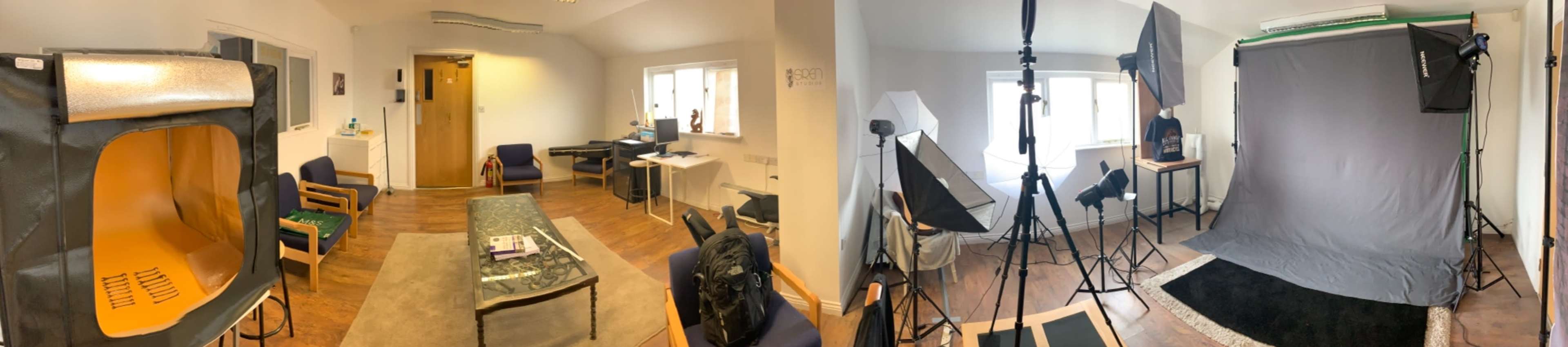The image shows a split view of a room with a seating area on one side and a photography setup with backdrops and lighting equipment on the other.
