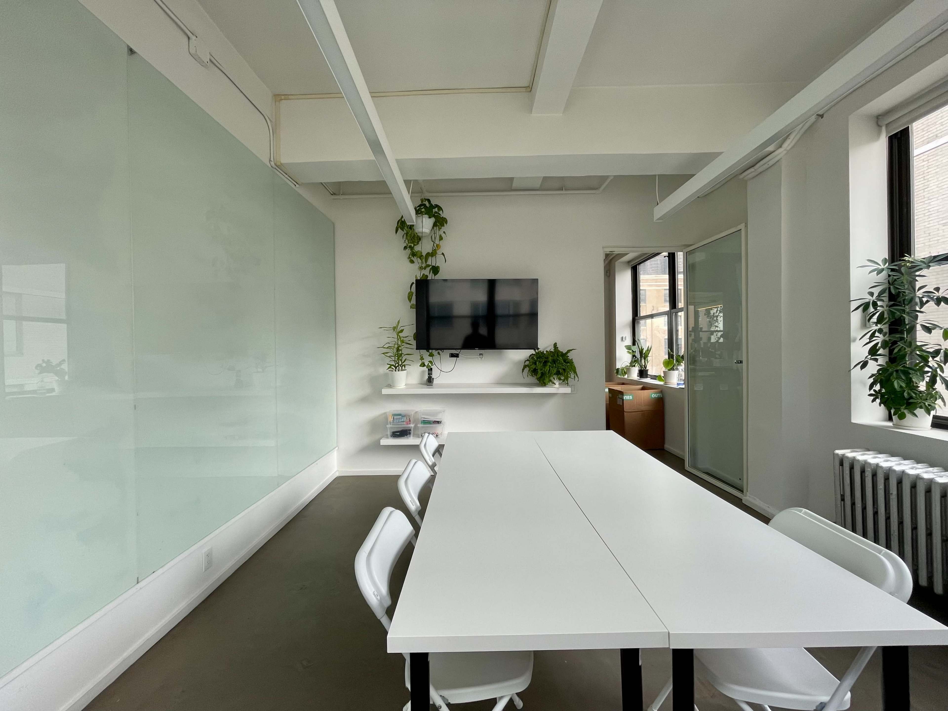 Light filled large meeting room with floor-to-ceiling white boards Image in Midtown Manhattan, New York, NY