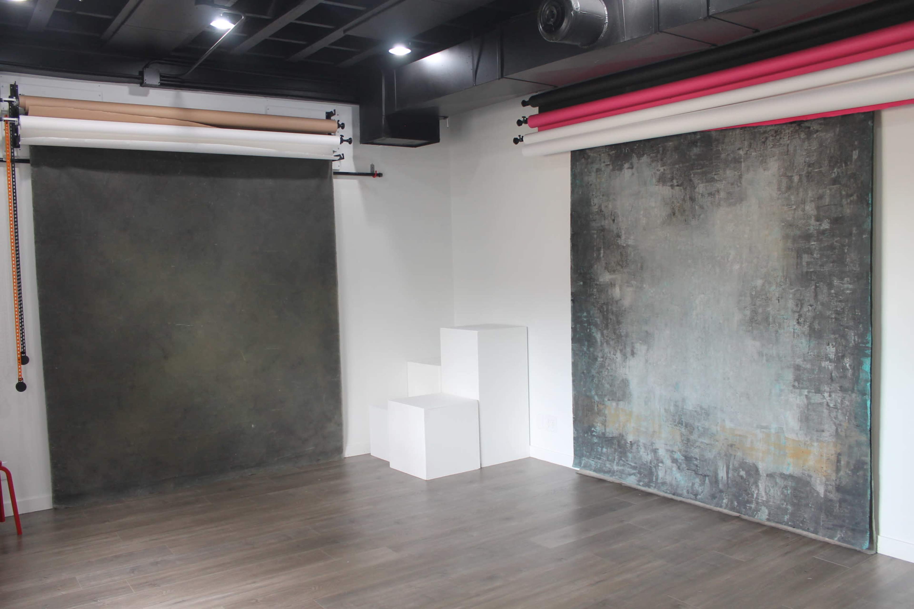 A photography studio with two large backdrop options on either side and white steps in the center.