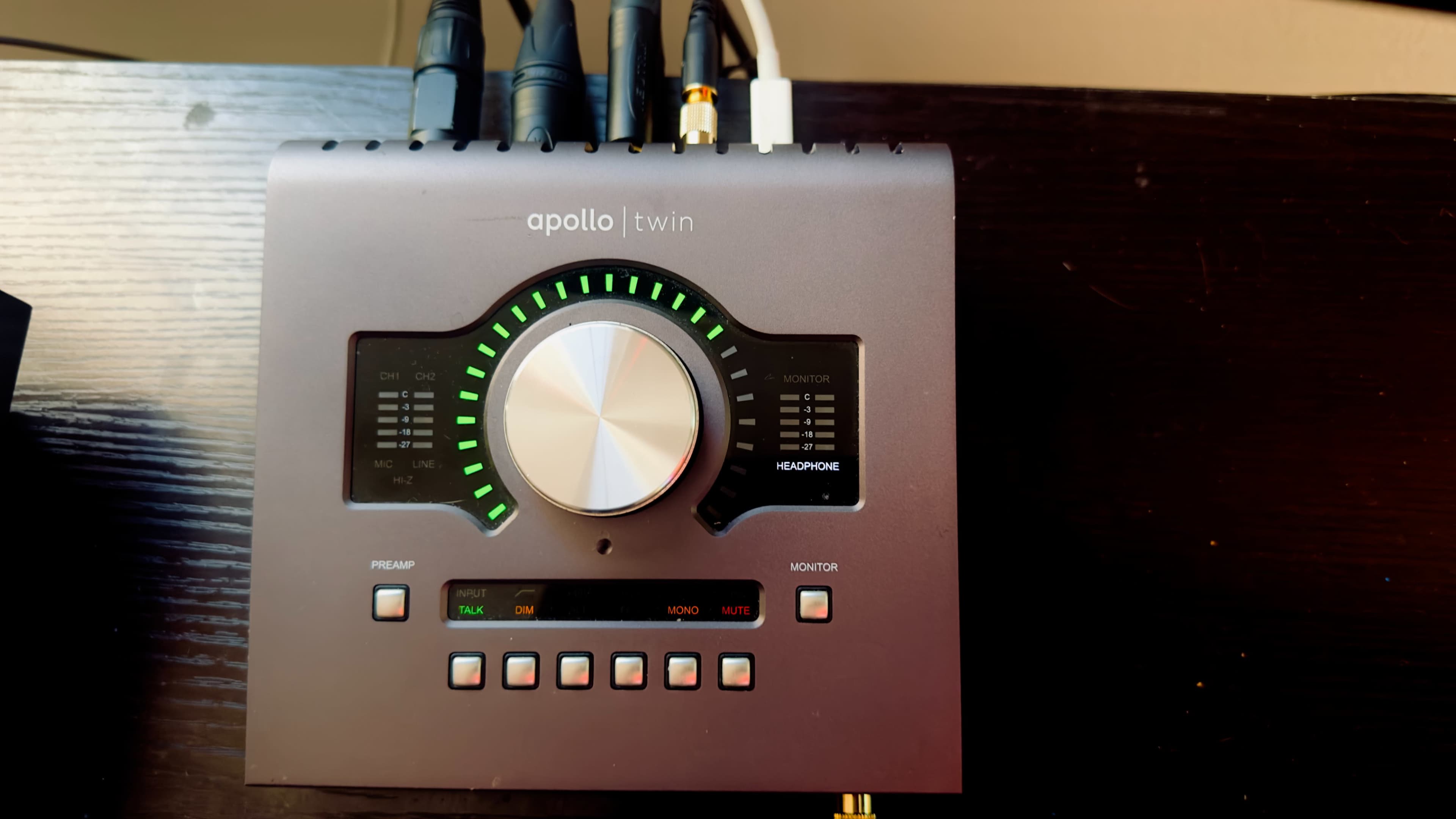 A black audio interface with a large central knob and multiple input/output connections at the back.