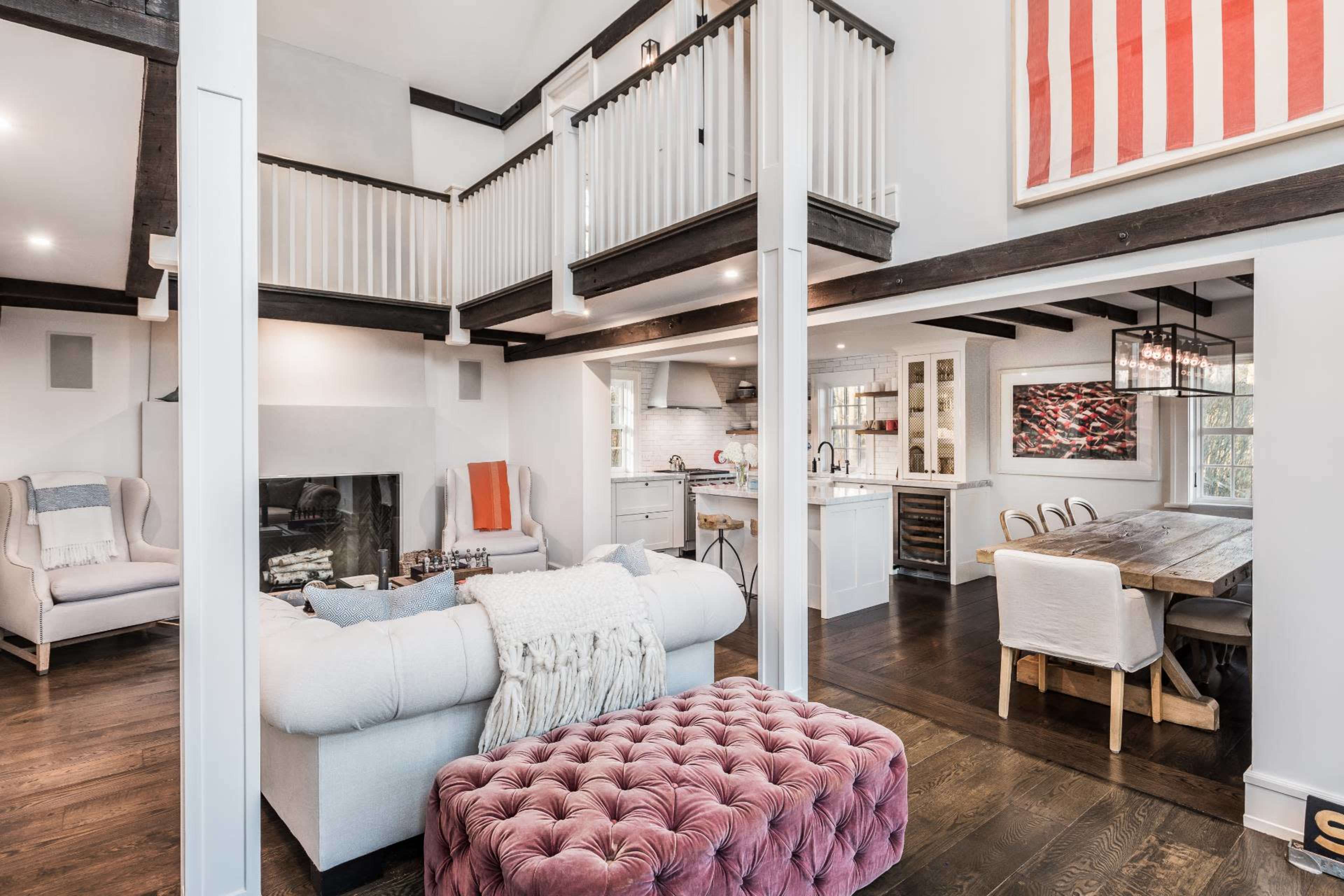 A modern living space featuring a two-story layout with a kitchen, dining area, and lounge, illuminated by ample natural light.