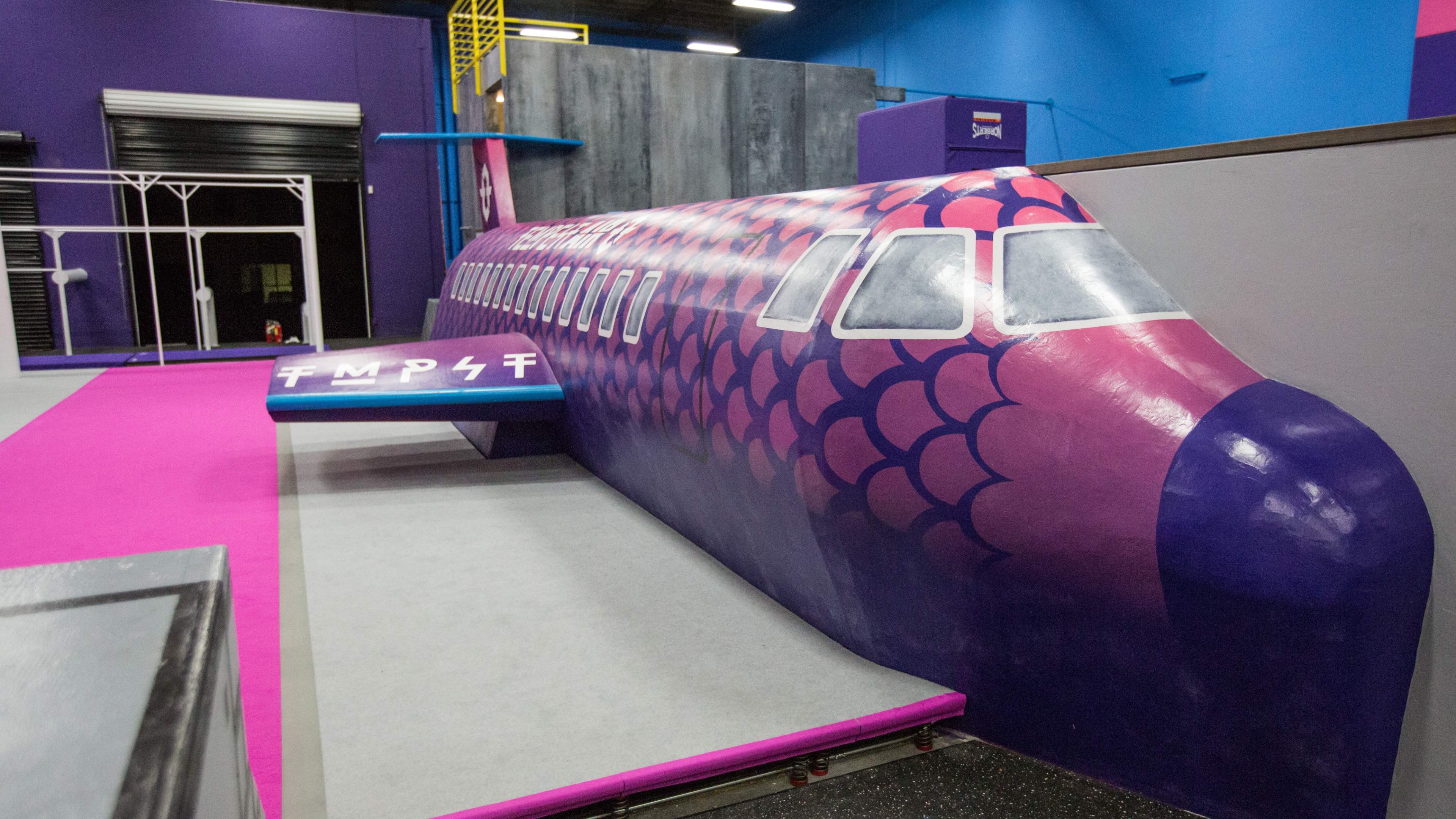 A colorful, stylized airplane structure integrated into a vibrant indoor space.
