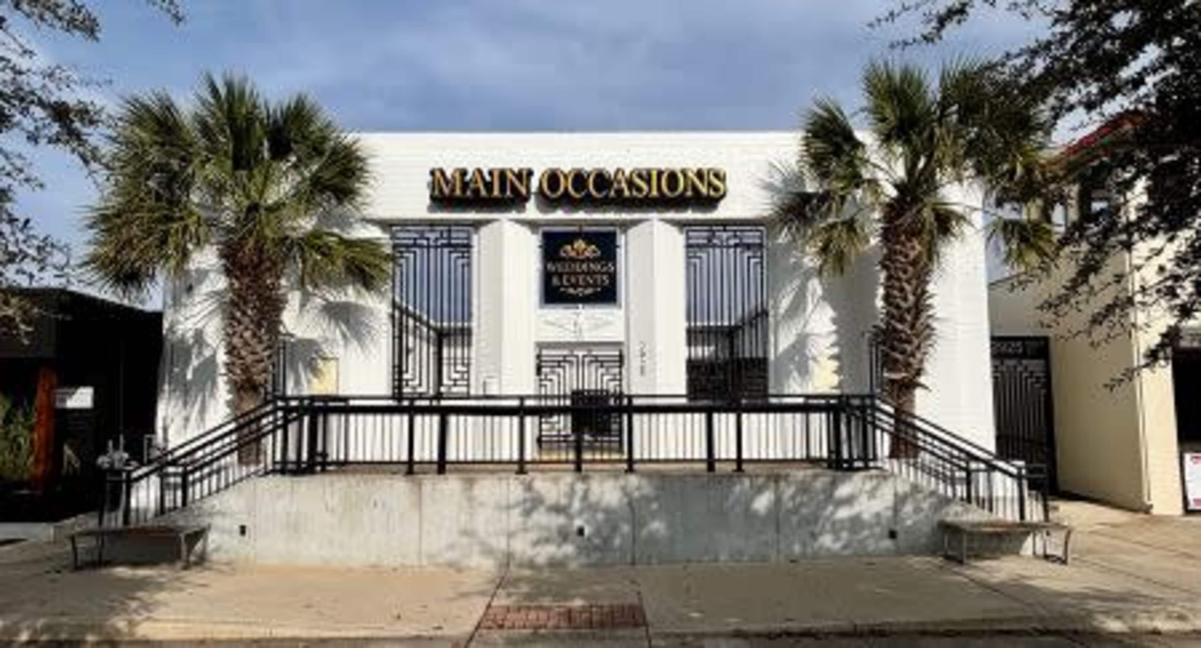The image shows a building with the sign "MAIN OCCASIONS," specializing in weddings and events, flanked by palm trees and featuring a staircase leading to the entrance.