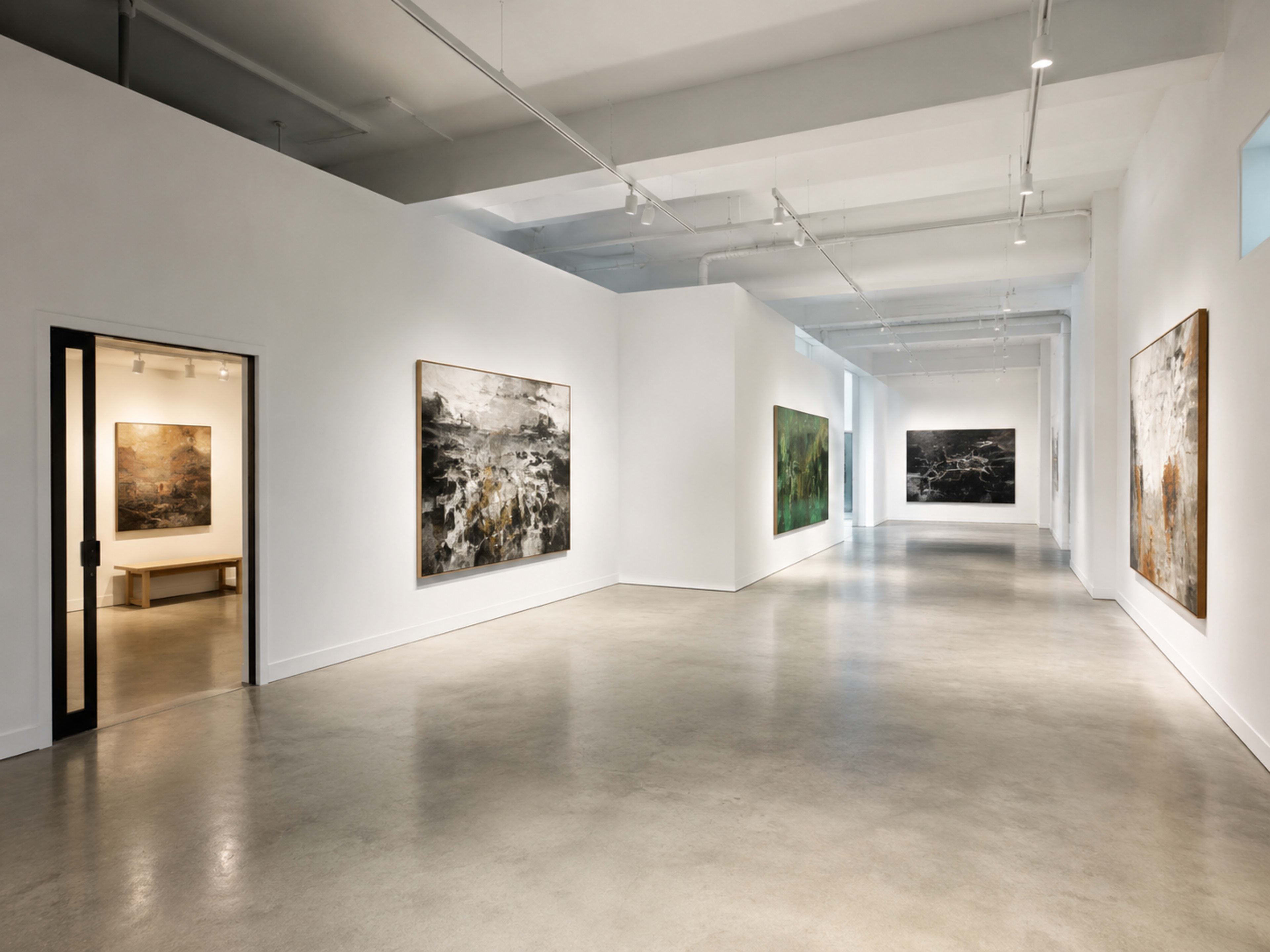 The image shows a spacious art gallery with several large abstract paintings displayed on the white walls and a bench positioned near an entrance.
