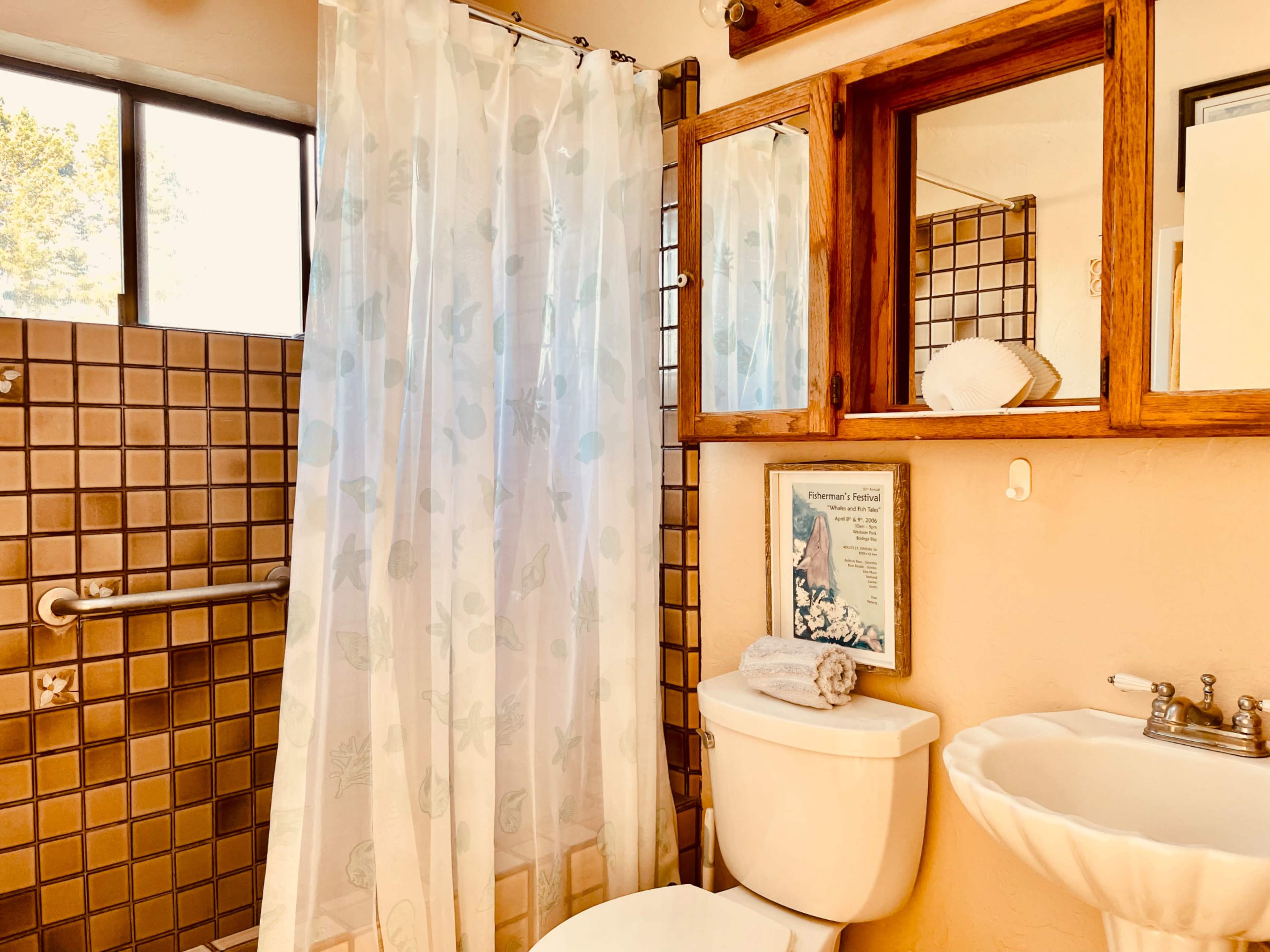 A bathroom with a shower, a toilet, a sink, and decorative wooden accents.