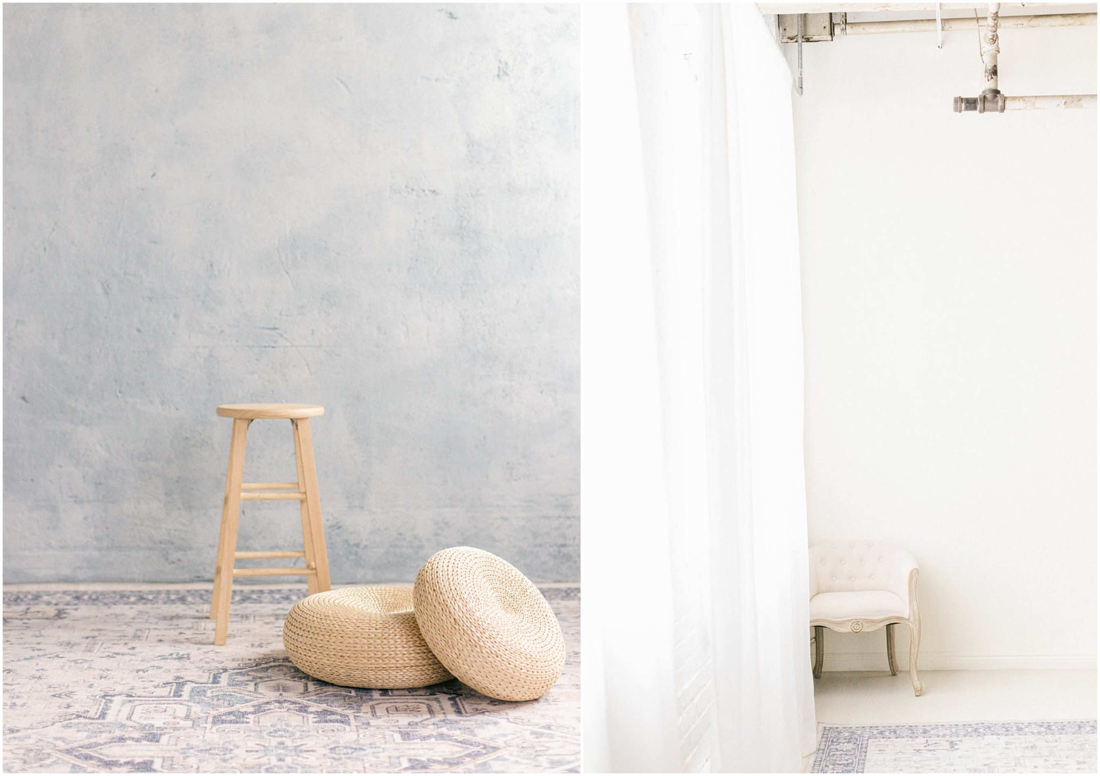 The image features a minimalistic interior with a wooden stool, two round woven cushions on a patterned rug, and a softly lit white curtain on one side.