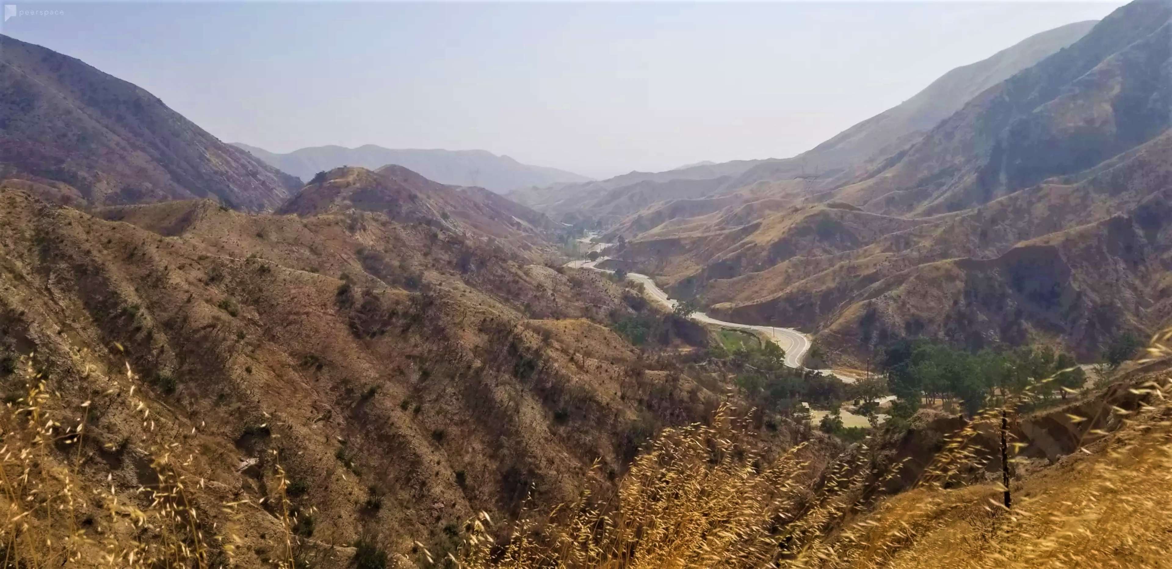 A winding river flows through a dry mountainous landscape with sparse vegetation and steep hillsides.