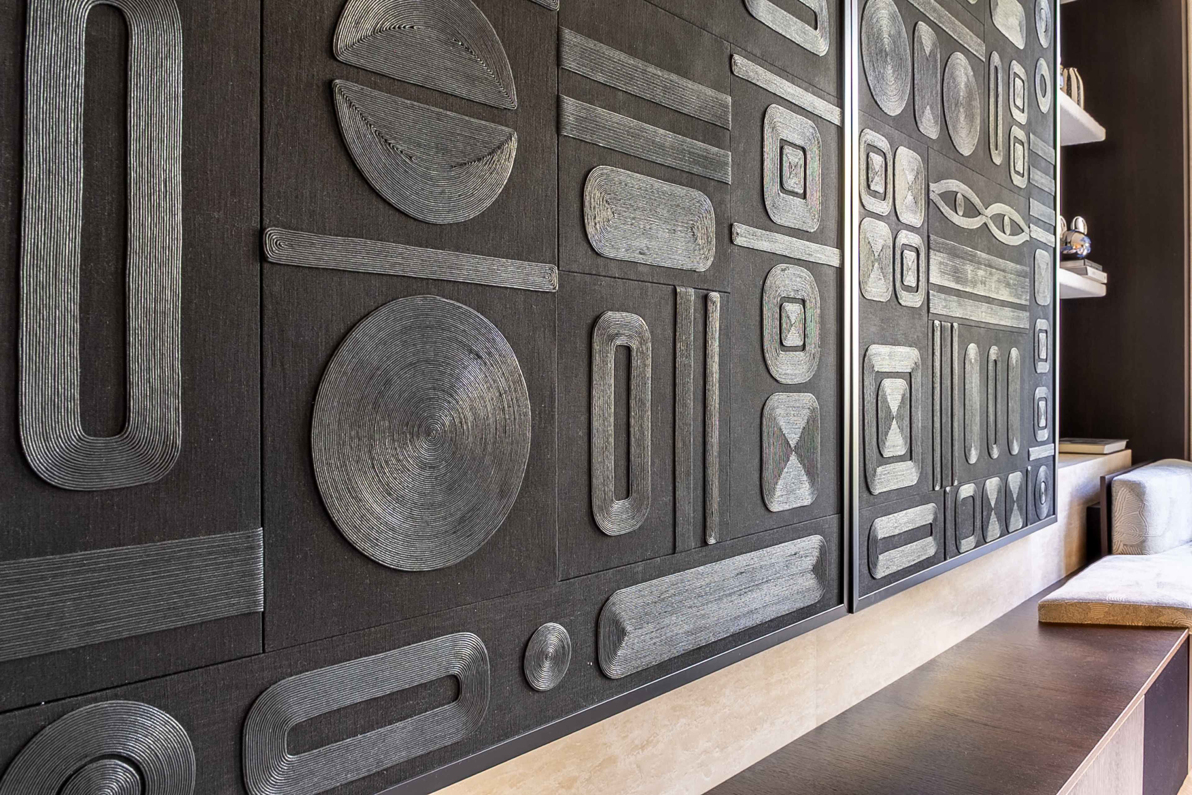 The image features a textured wall design composed of various geometric shapes in a monochromatic color scheme.