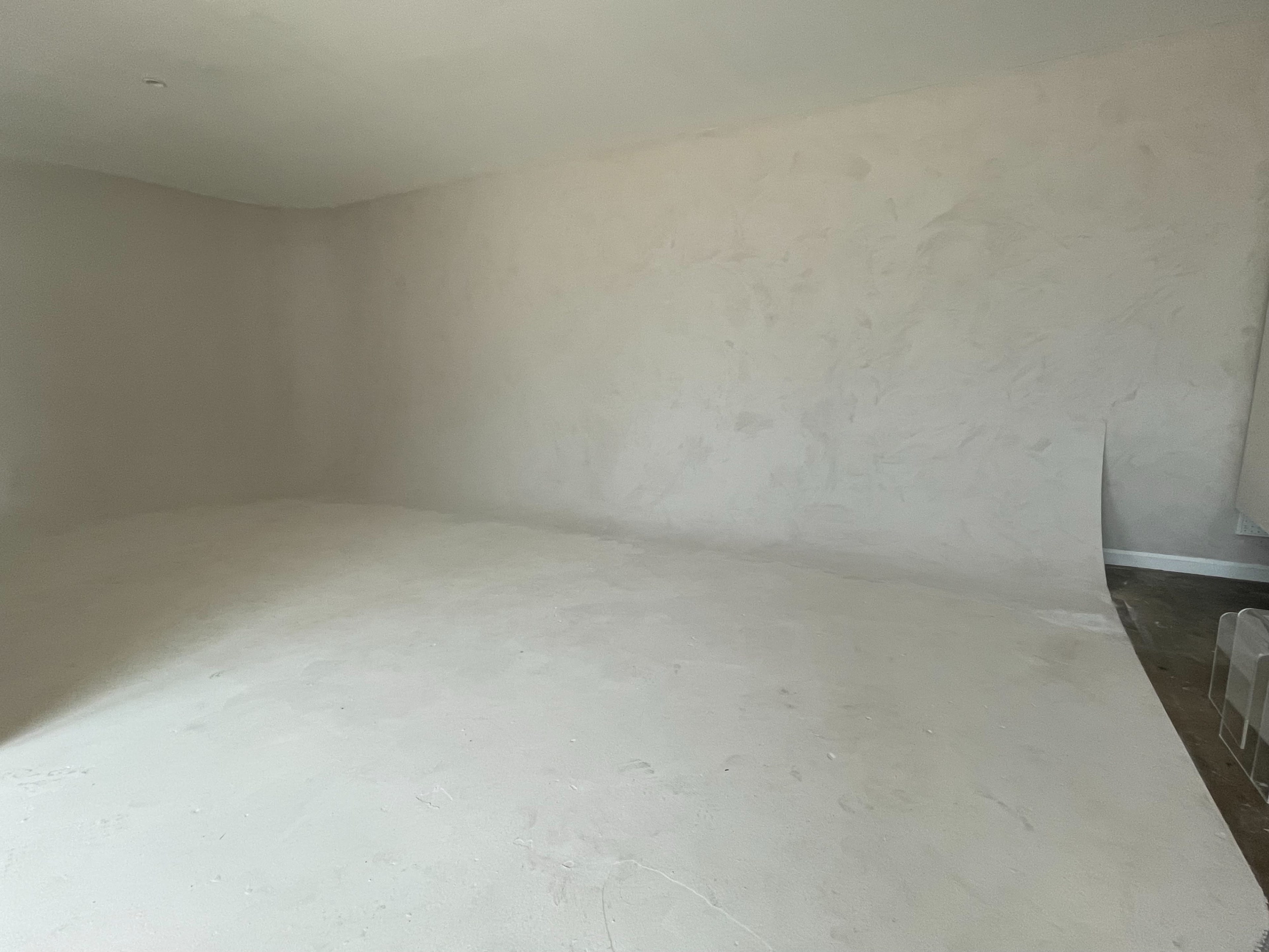 An empty room with unadorned walls and a bare floor.