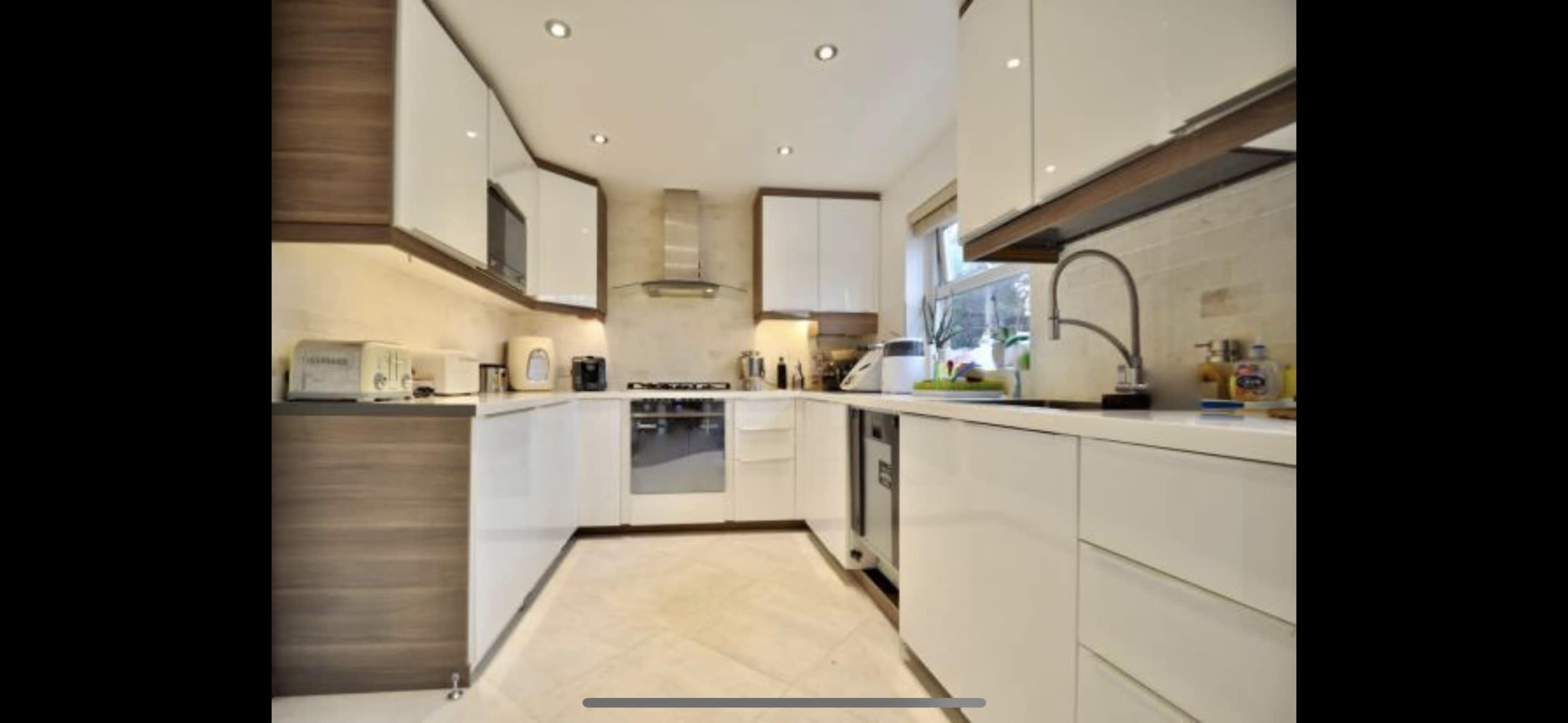 The kitchen features modern cabinetry, stainless steel appliances, and a minimalist layout with white and wood finishes.