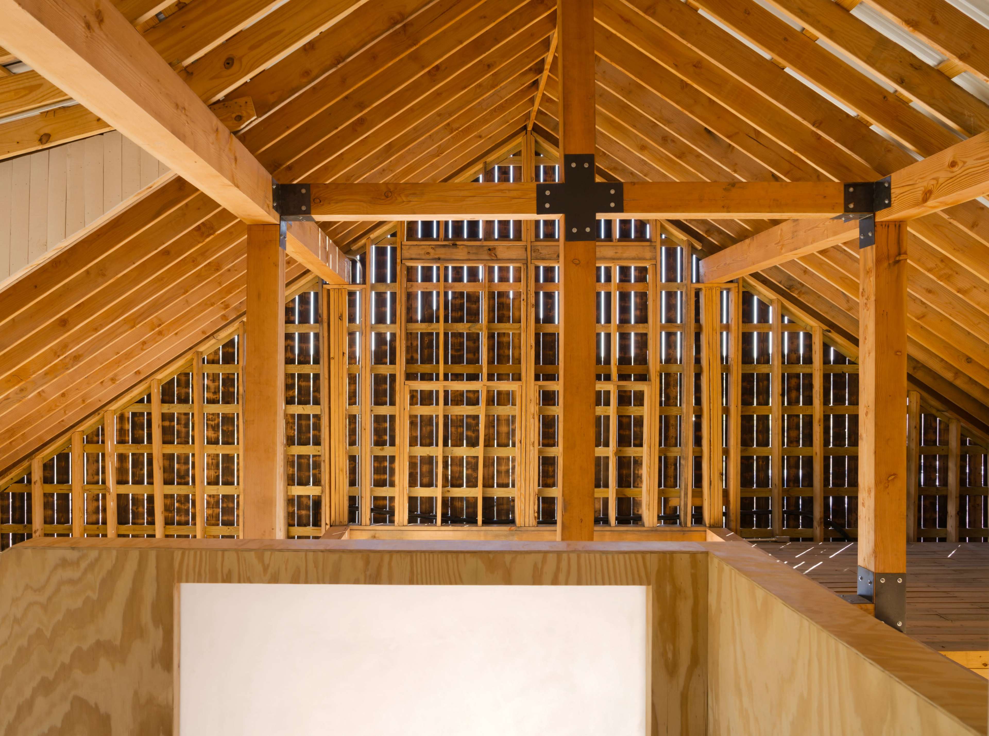 The image shows a wooden attic structure with exposed beams and a lattice wall design.