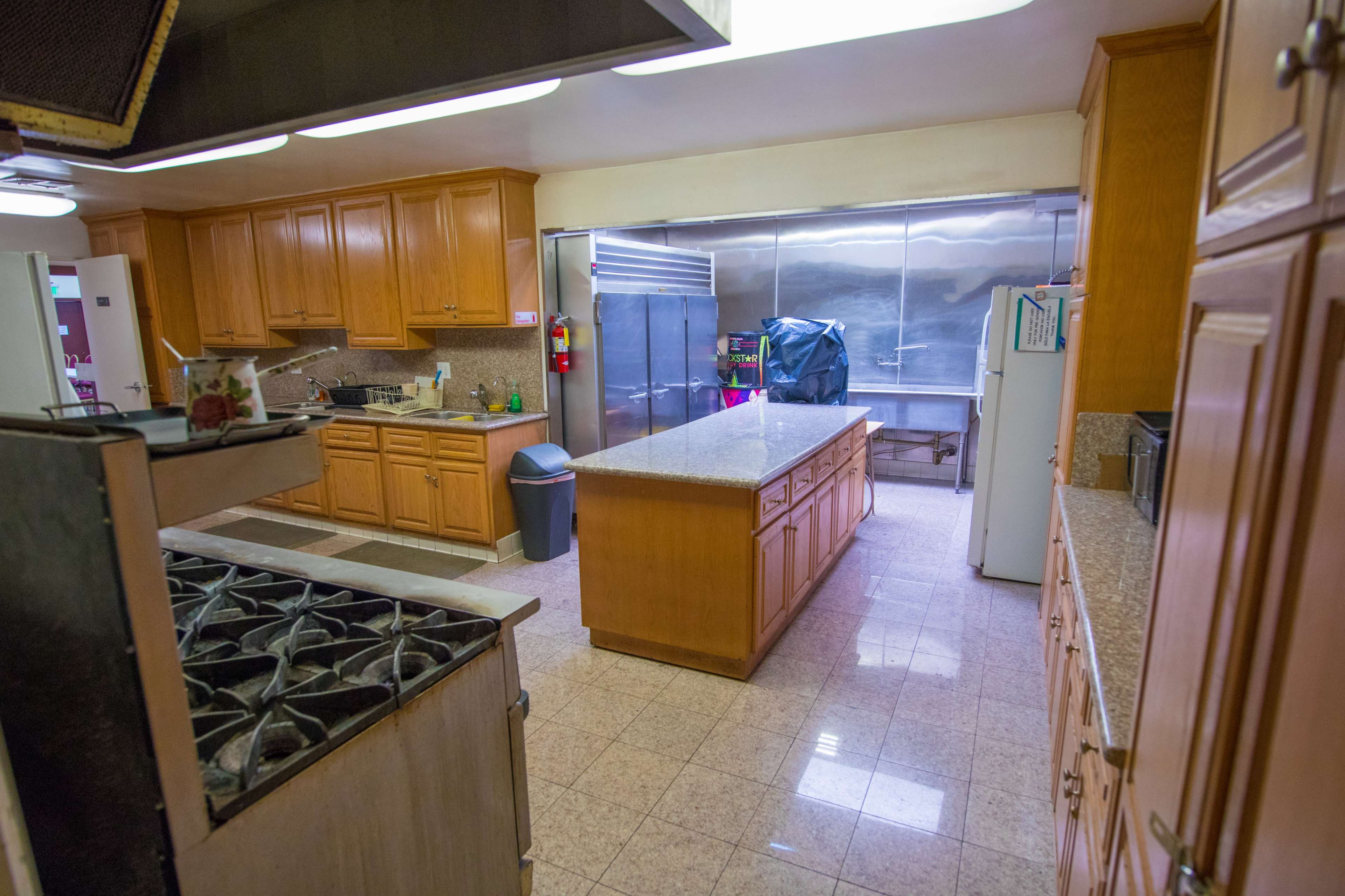 A spacious kitchen with wooden cabinets, a large island, and stainless steel appliances.