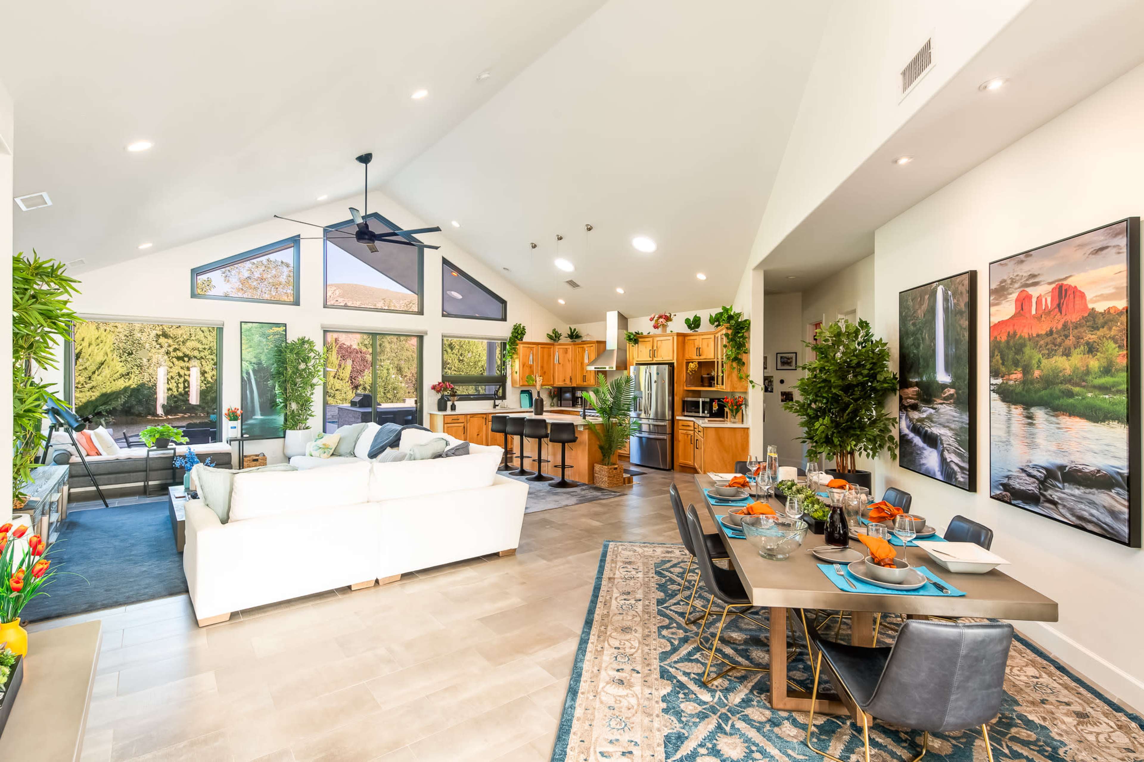 The open-concept living and dining area features a modern kitchen, a spacious seating arrangement, and large windows that overlook a landscaped outdoor space.