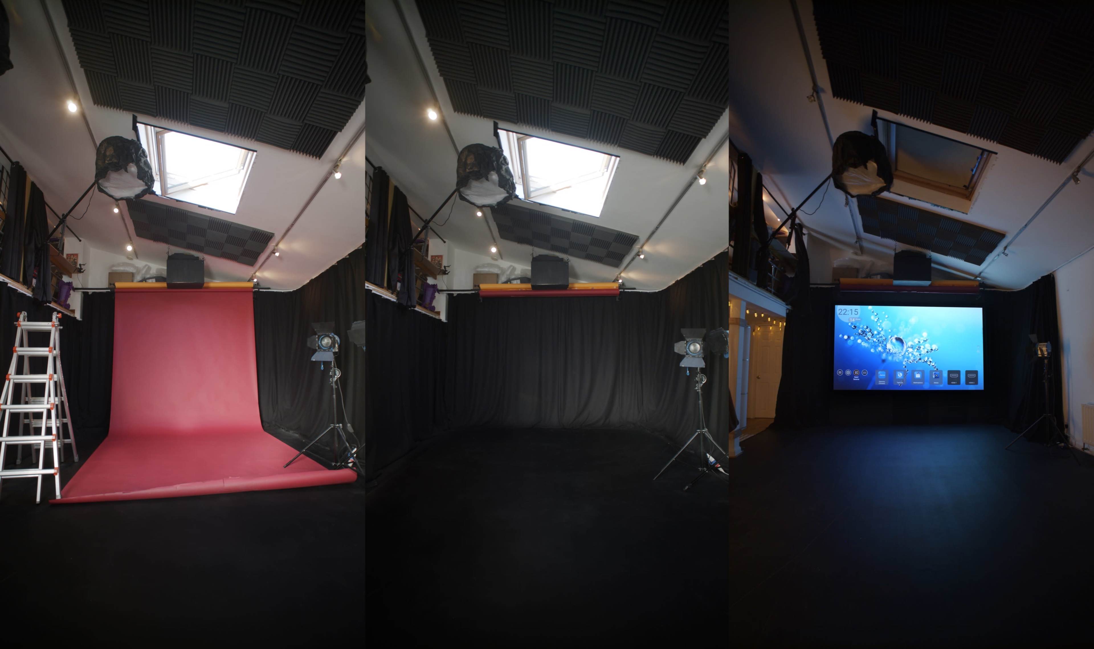A photography studio with a red backdrop, lighting equipment, and a large screen on a black floor.