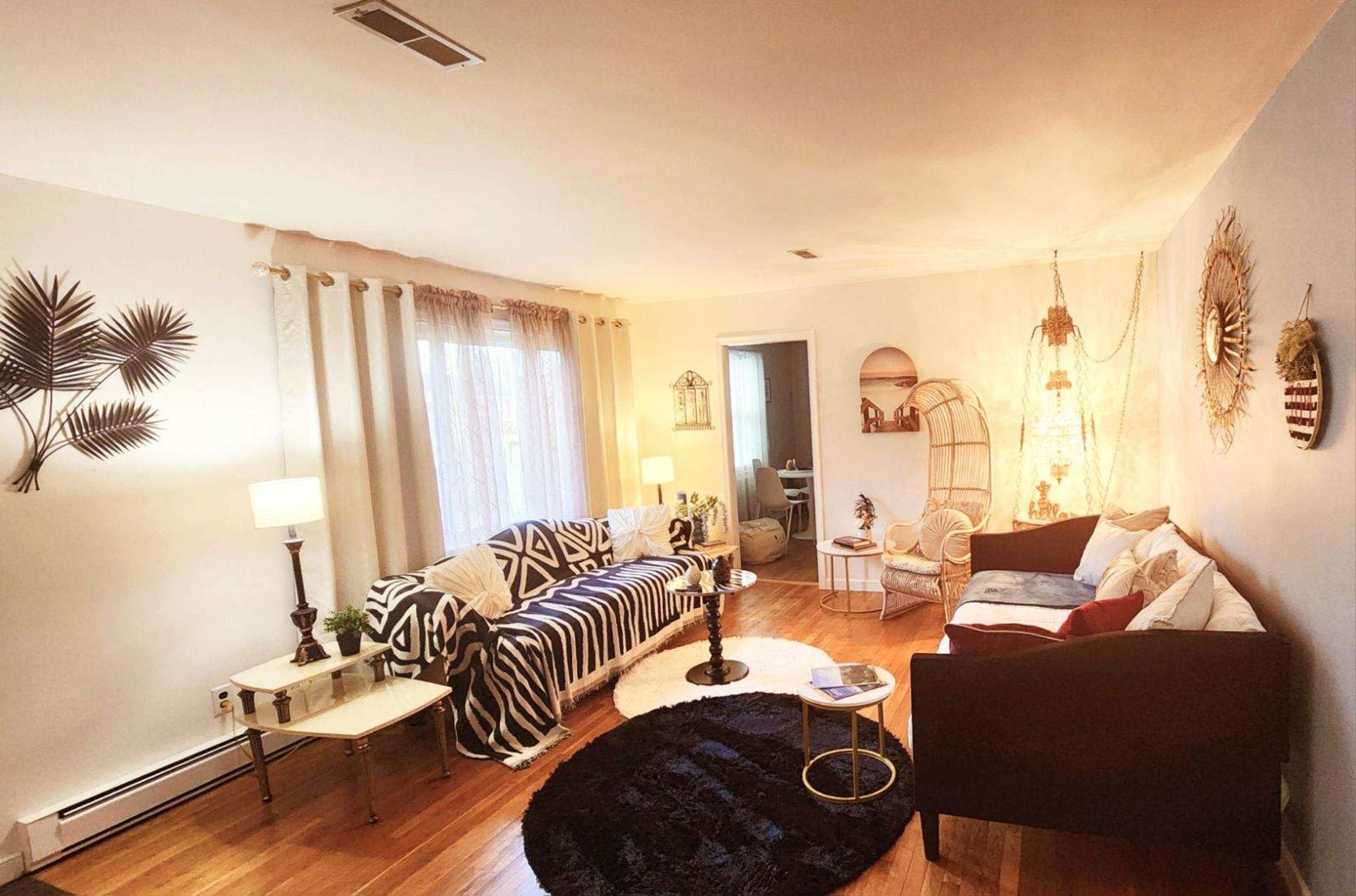 The living room features a mix of patterned furniture, a round rug, and soft lighting.