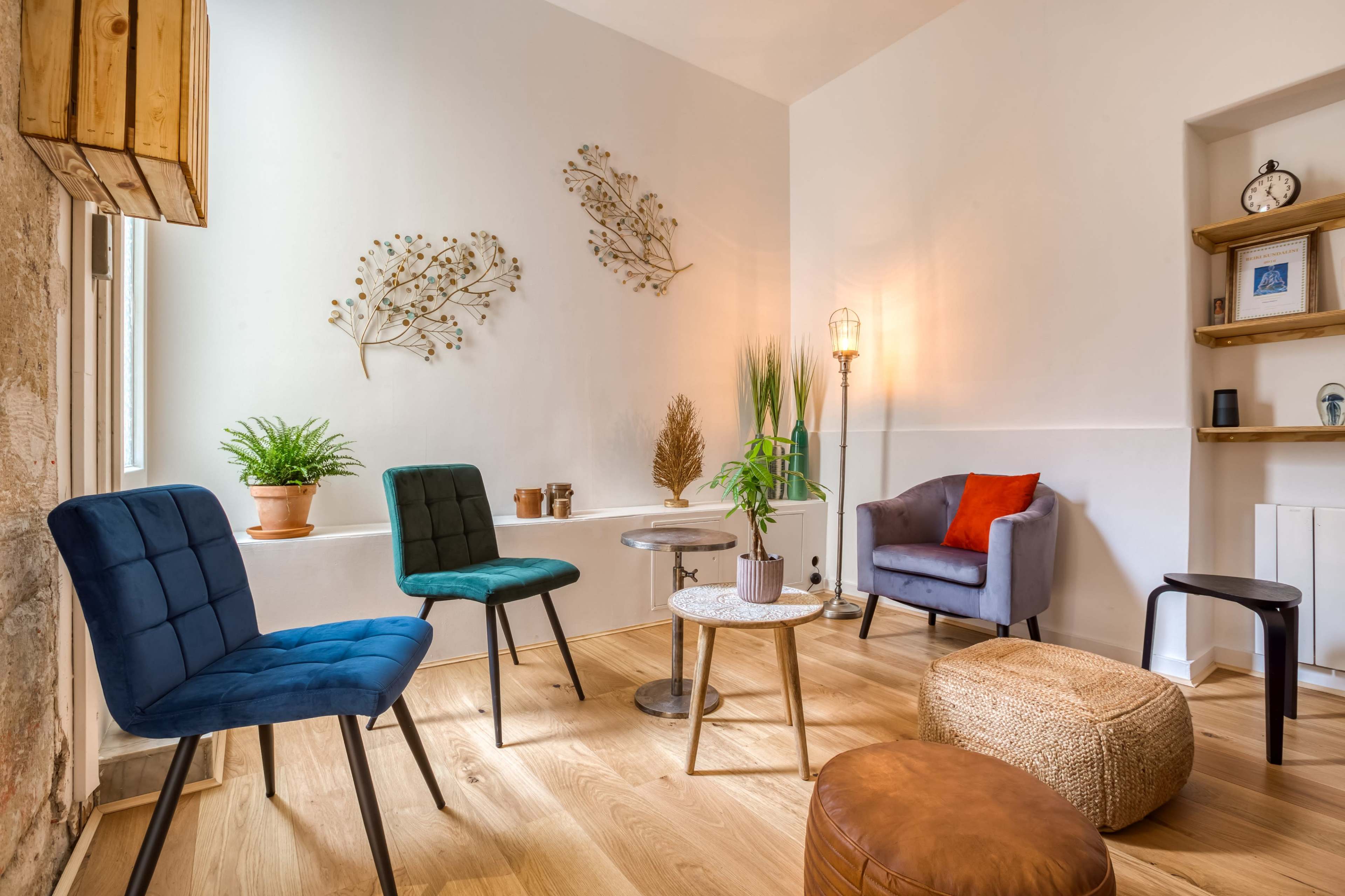 A cozy room with four chairs, a small table, and various decorative plants and wall art.