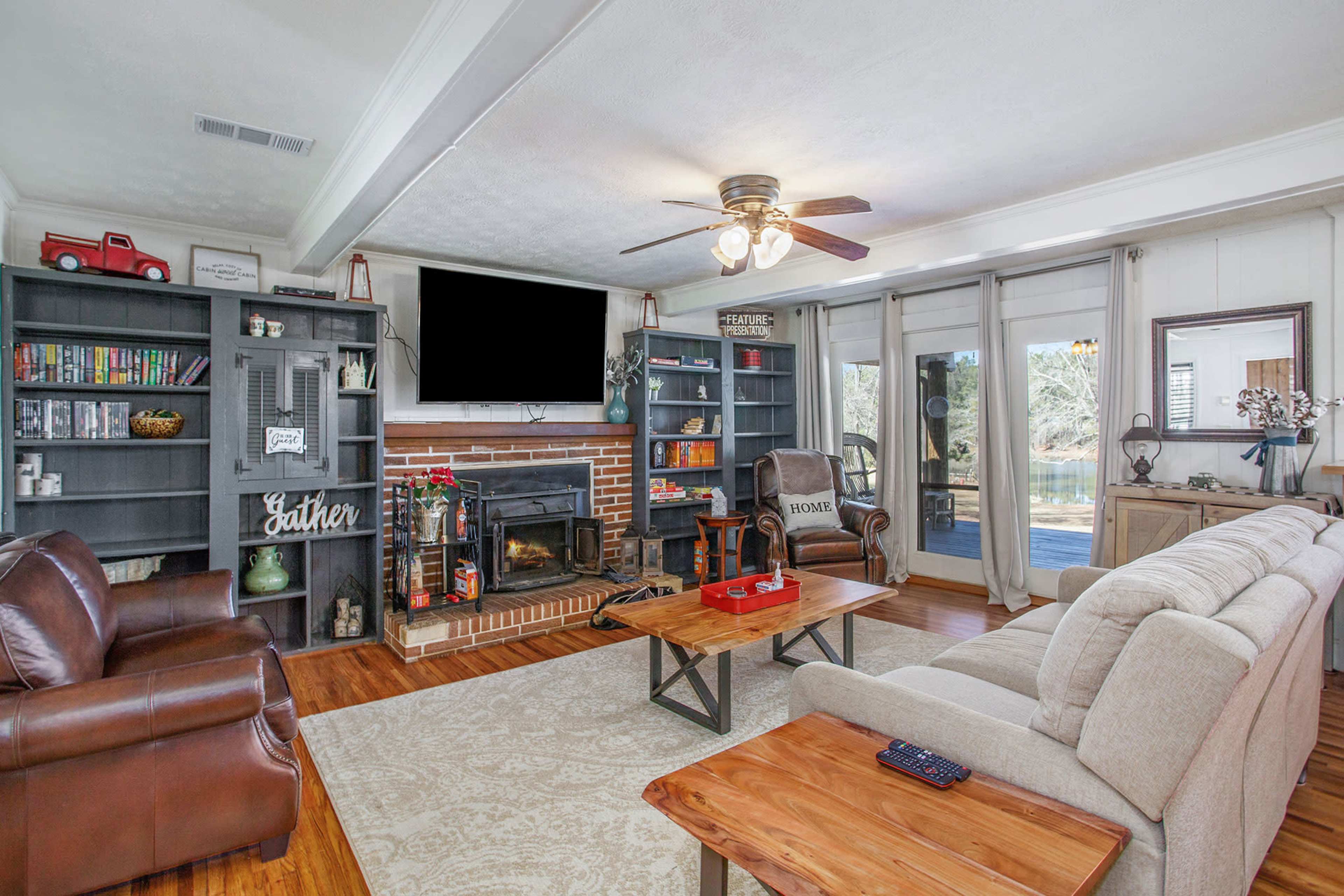 The living room features a brick fireplace, a wall of built-in shelves, and a set of sliding glass doors leading to an outdoor view.
