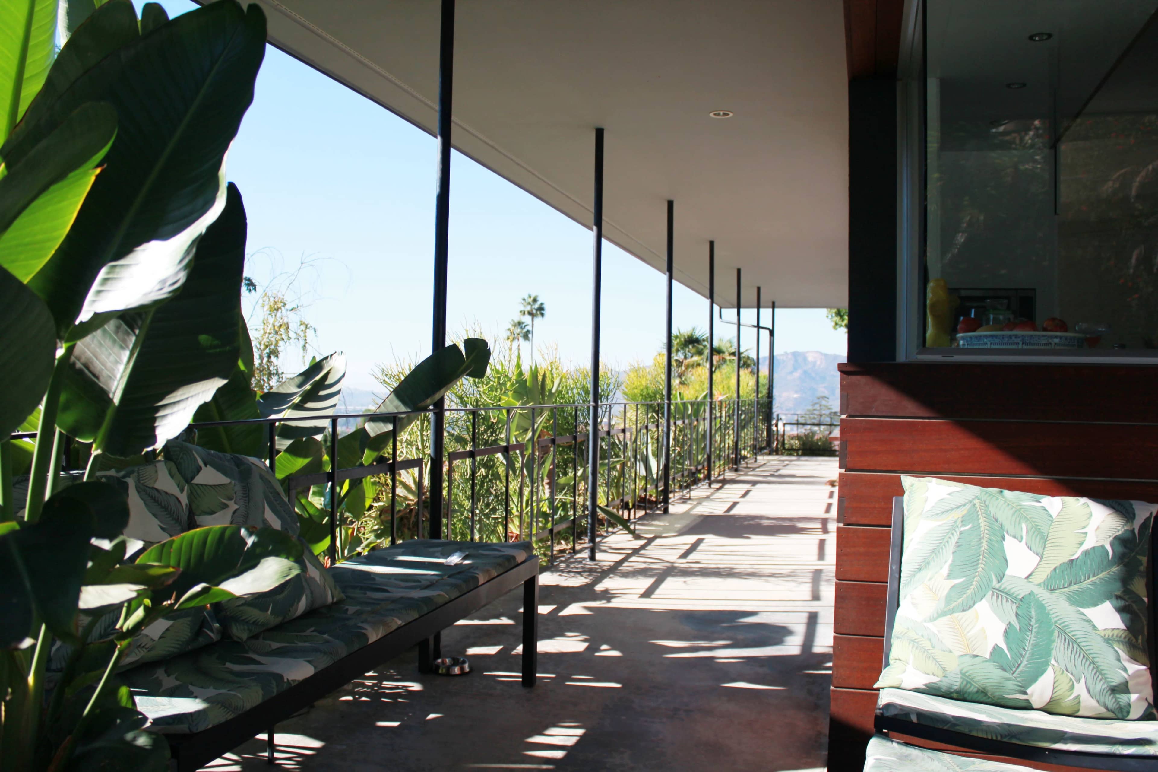 A patio area features green plants and seating alongside a clear view of the surrounding landscape.