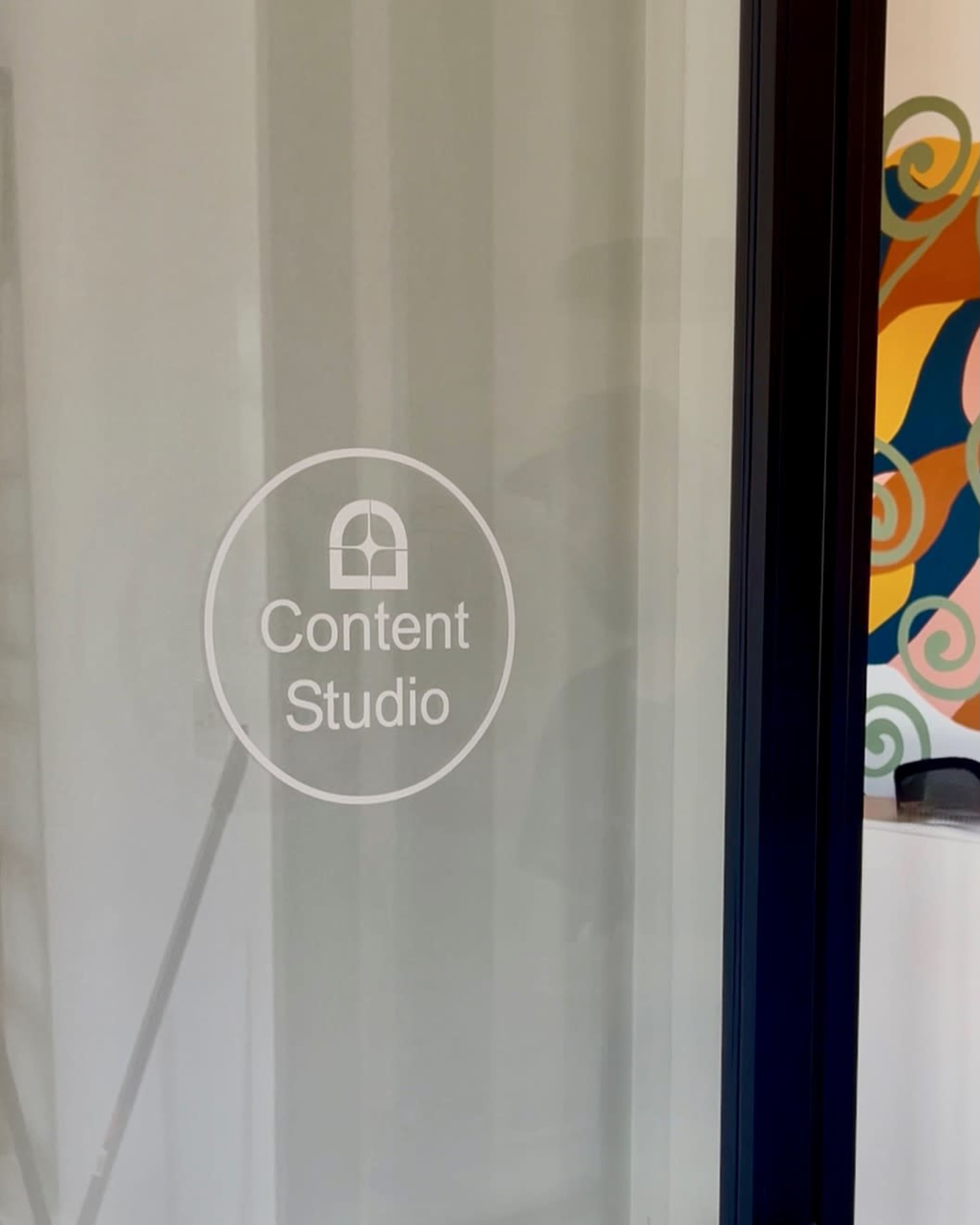A frosted glass door features a circular logo with the text "Content Studio" displayed prominently.