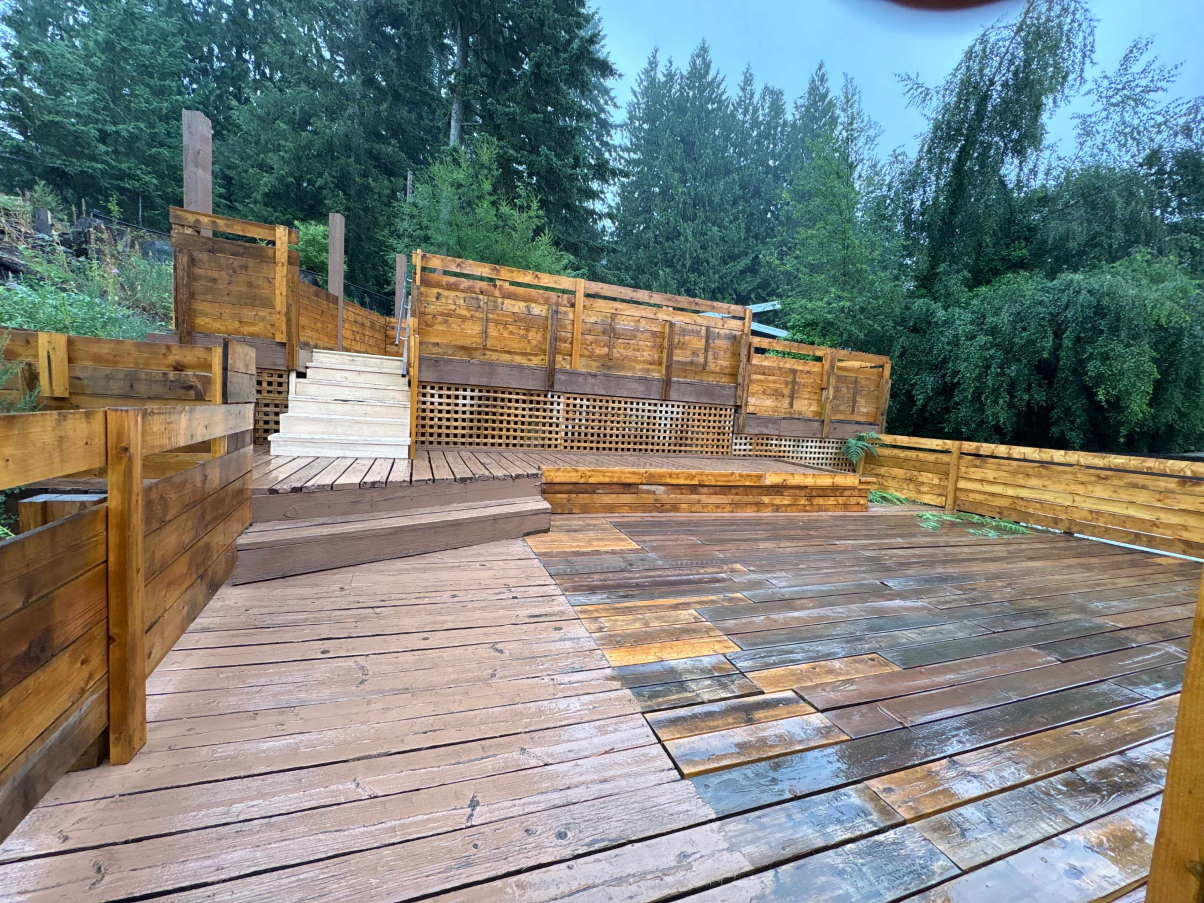 The image shows a wooden deck area with multiple levels and surrounding greenery.
