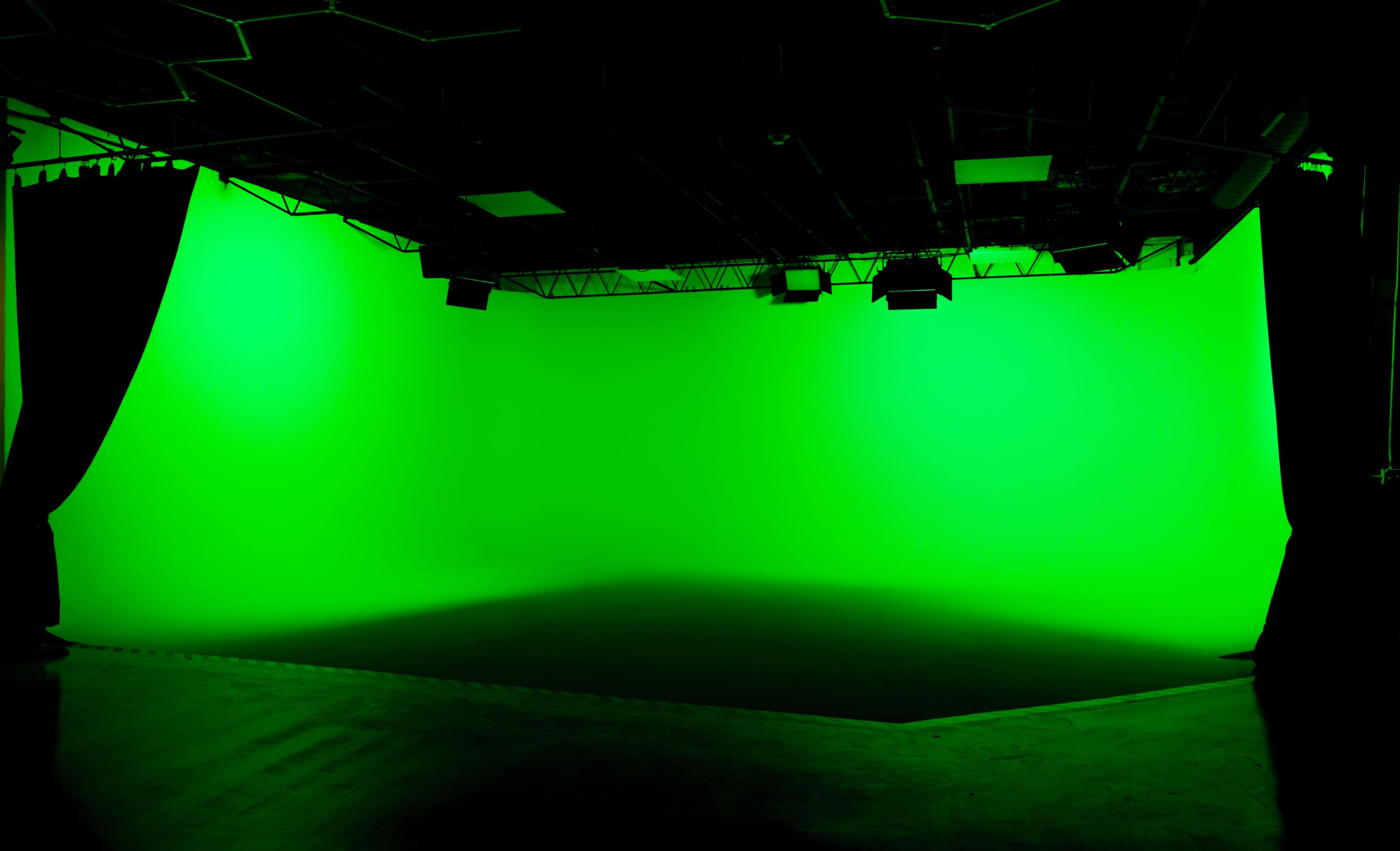 A green screen studio with a seamless green backdrop and overhead lighting.
