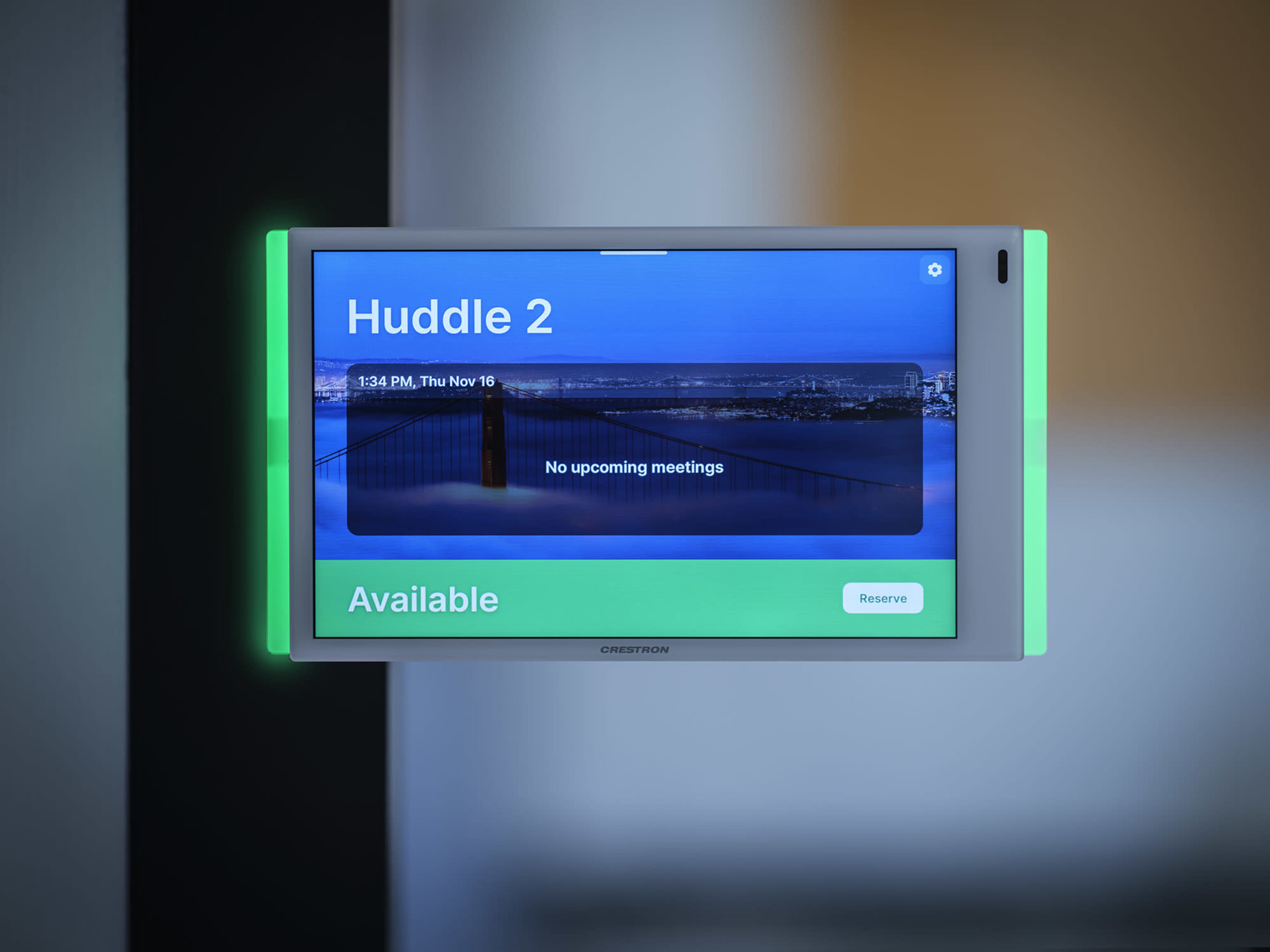 A digital meeting room scheduler displays "Huddle 2" with the message "No upcoming meetings" and a reserve option.