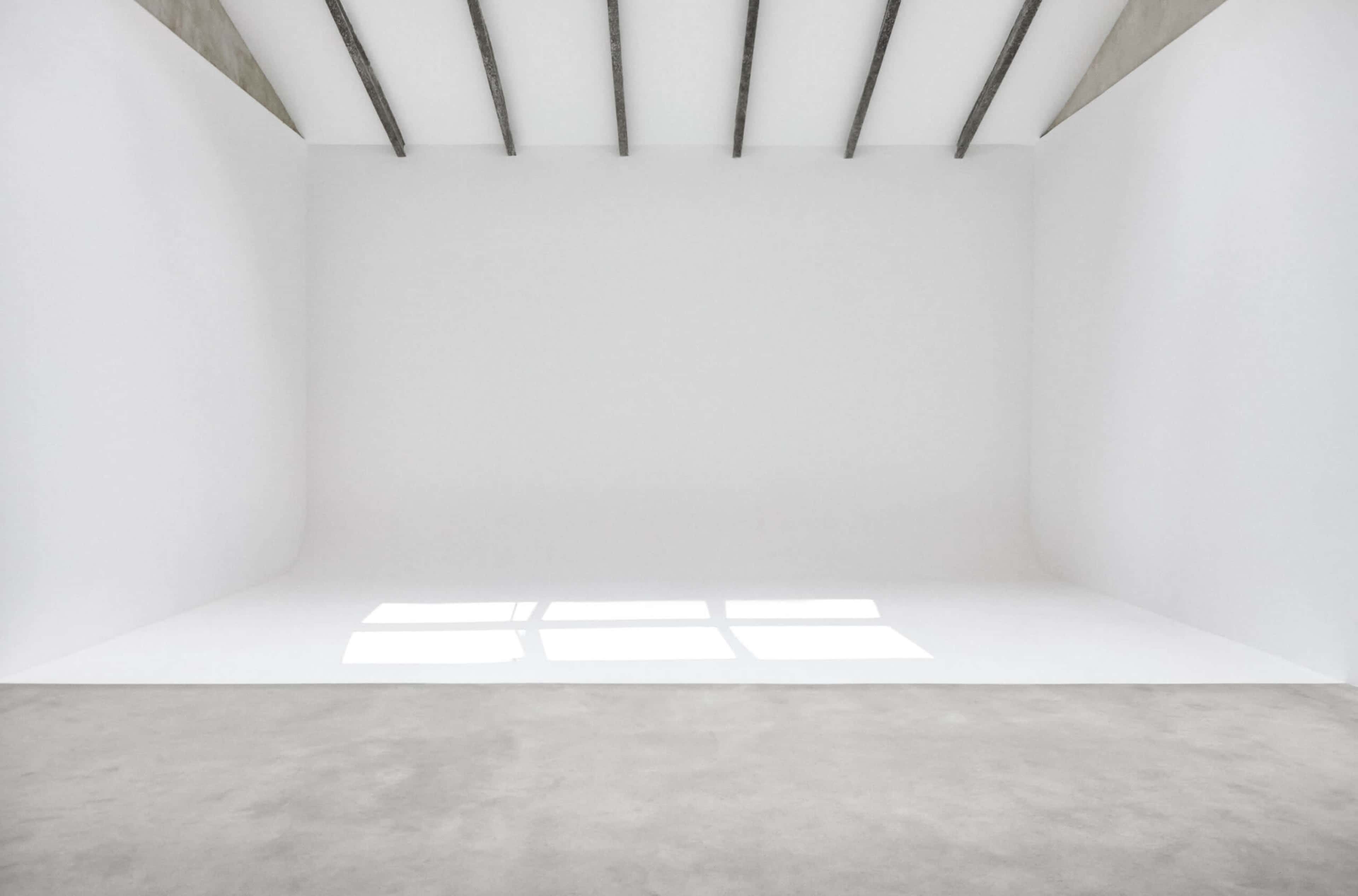 The image shows a minimalist interior space with white walls, a smooth floor, and exposed beams on the ceiling.