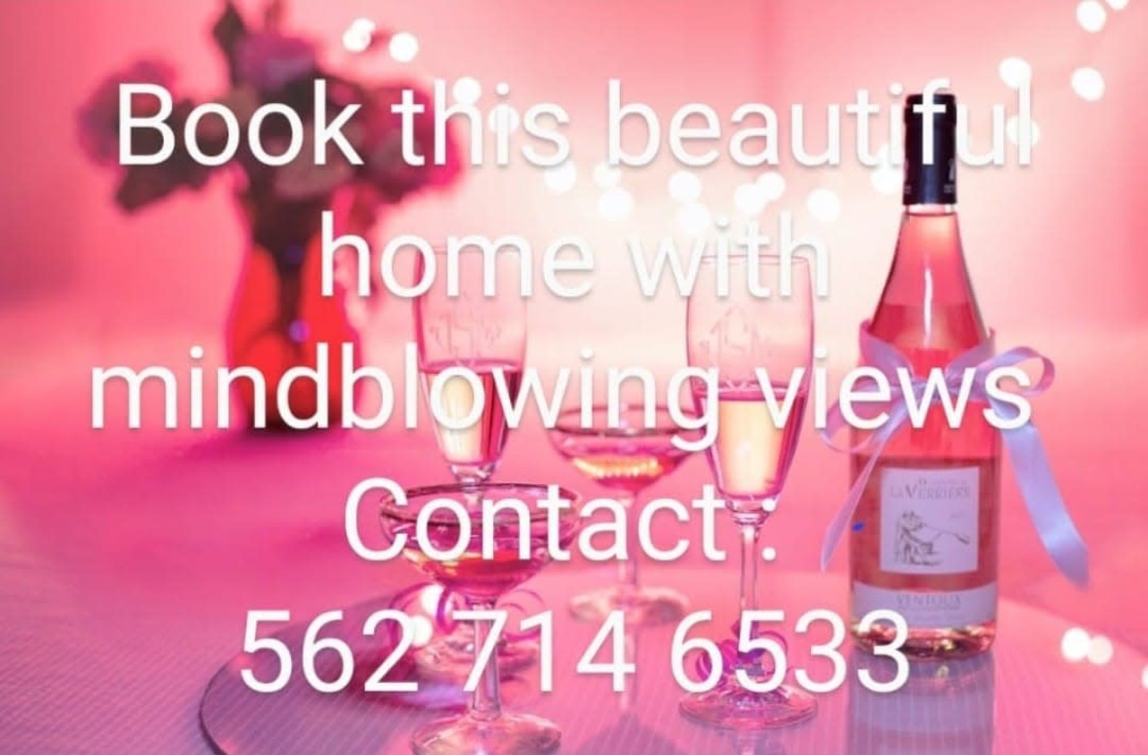 The image features three glasses of rosé wine in front of a softly lit pink background, advertising a home with views for booking.