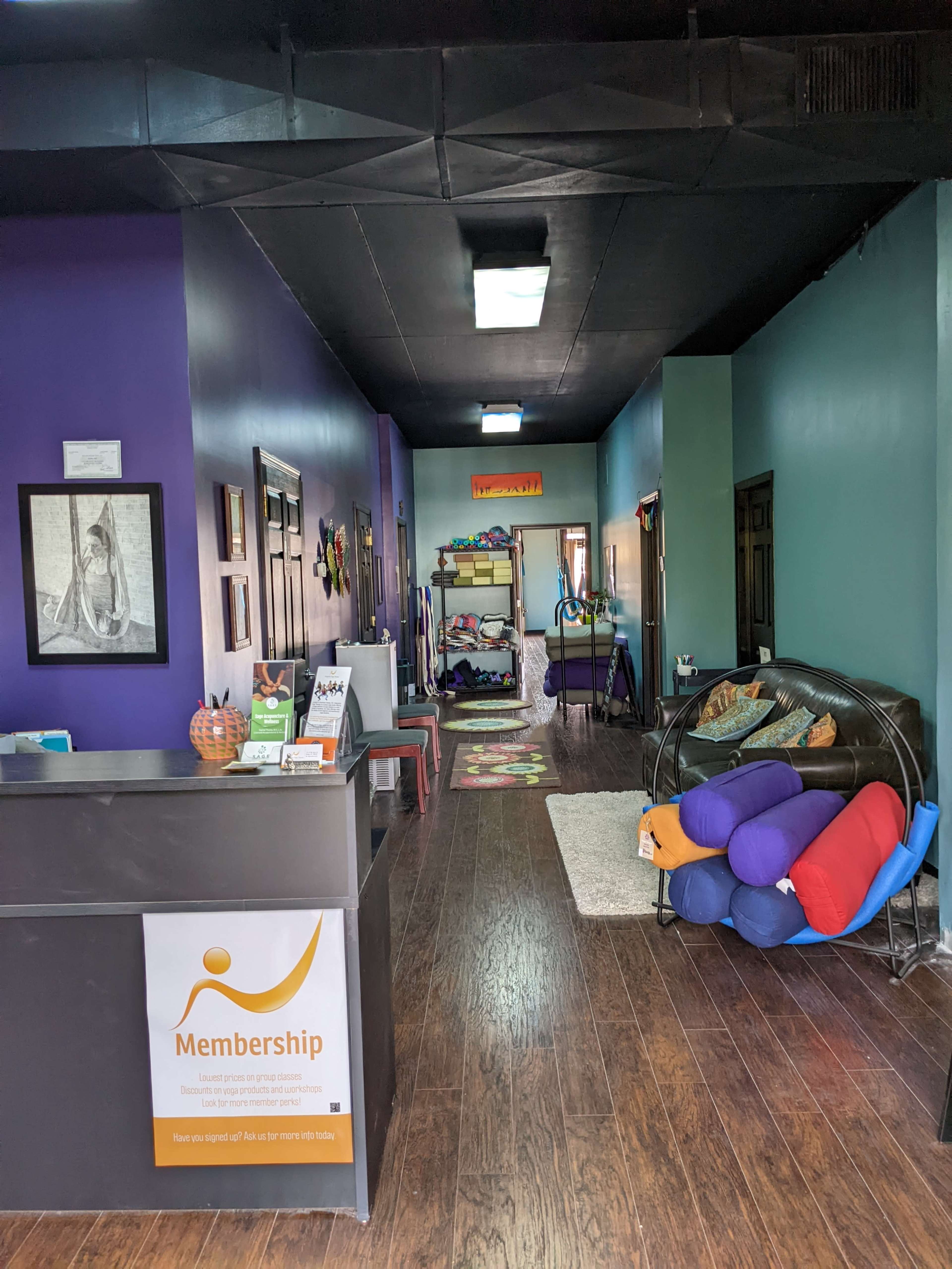 The interior of a membership office with a reception desk and a hallway leading to a colorful play area.
