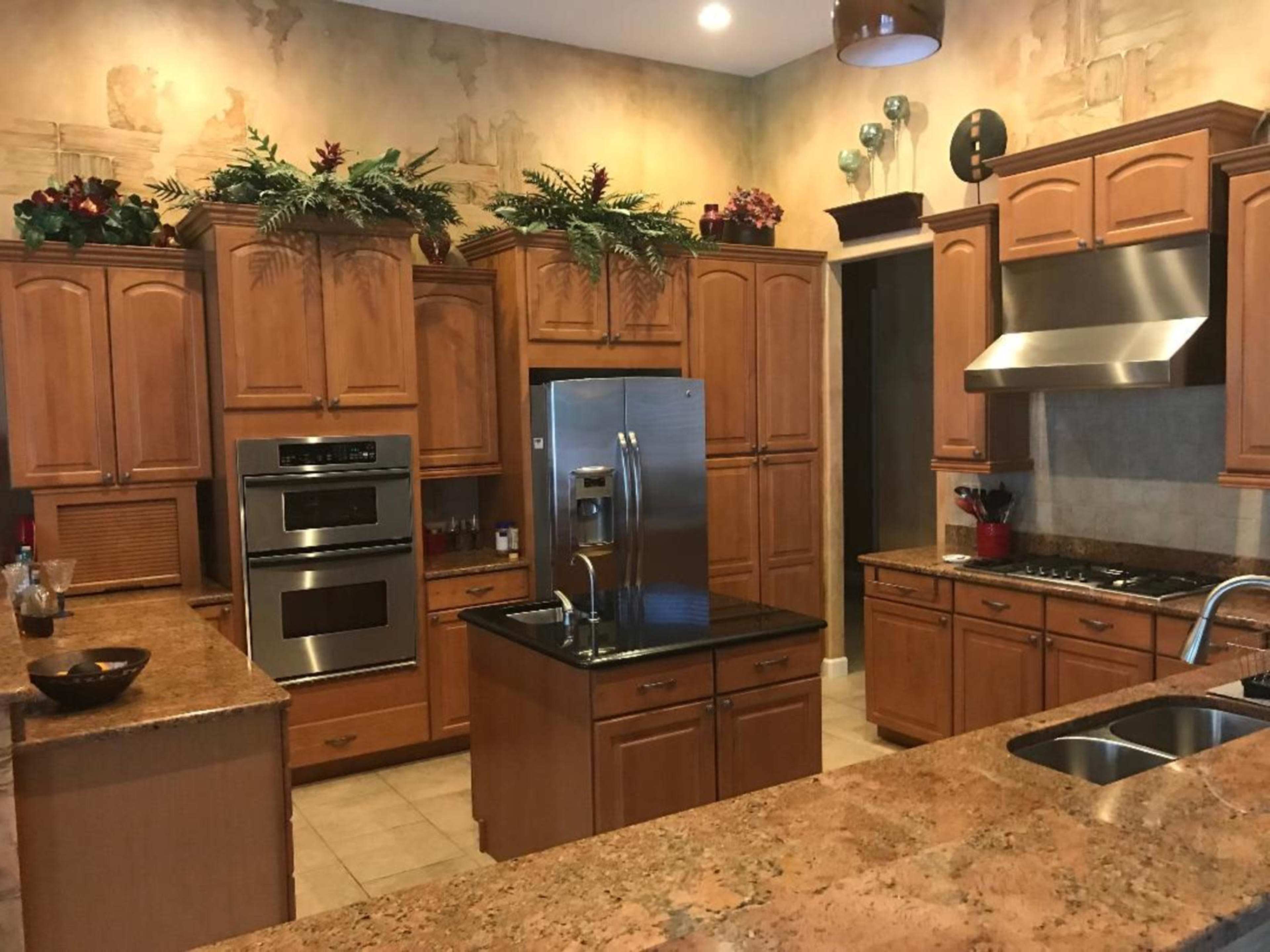 The kitchen features wooden cabinetry, modern appliances, and a central island with a dark countertop.