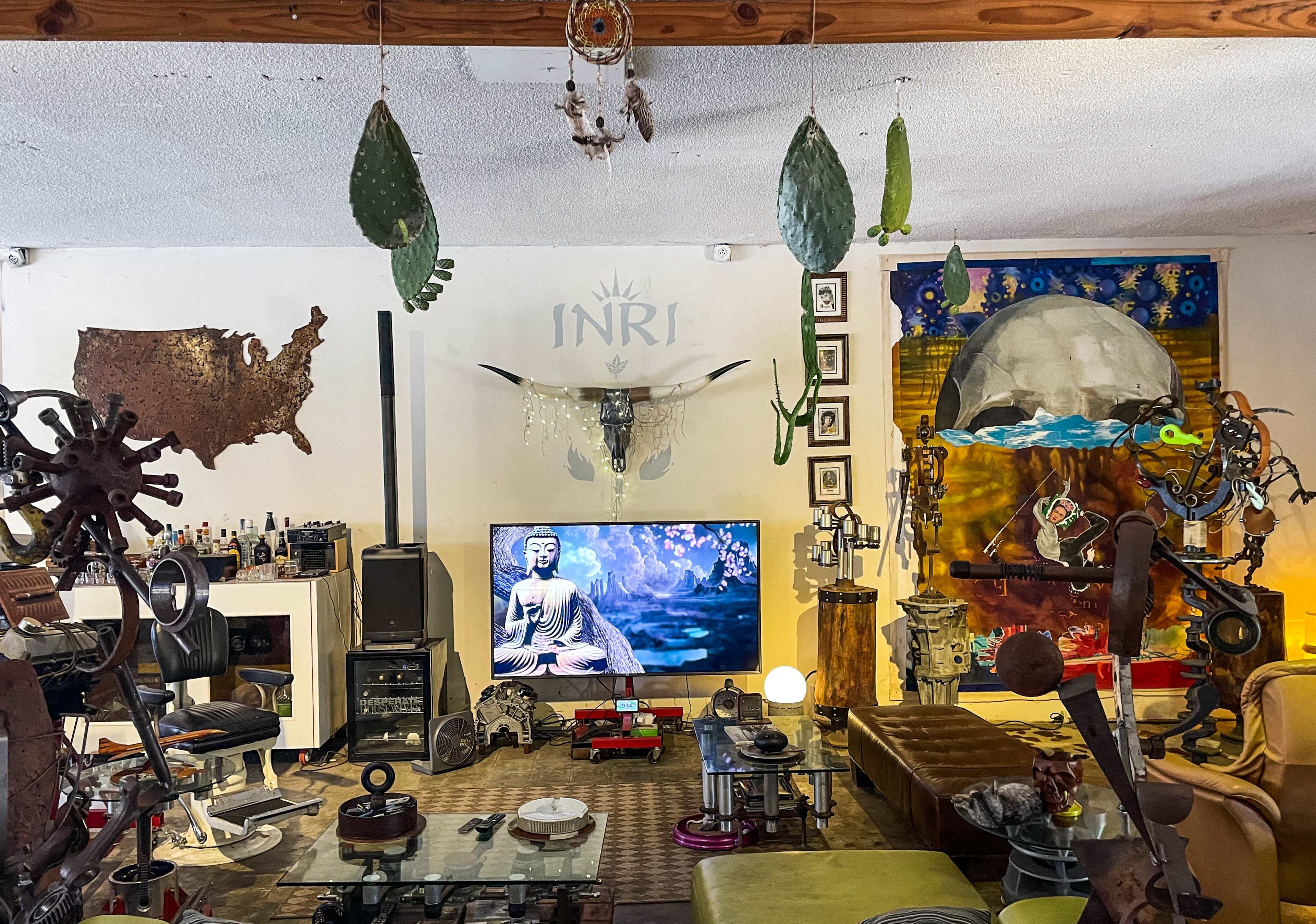 The scene features a room decorated with eclectic artwork, a television displaying a serene image, and various decorative objects scattered throughout.