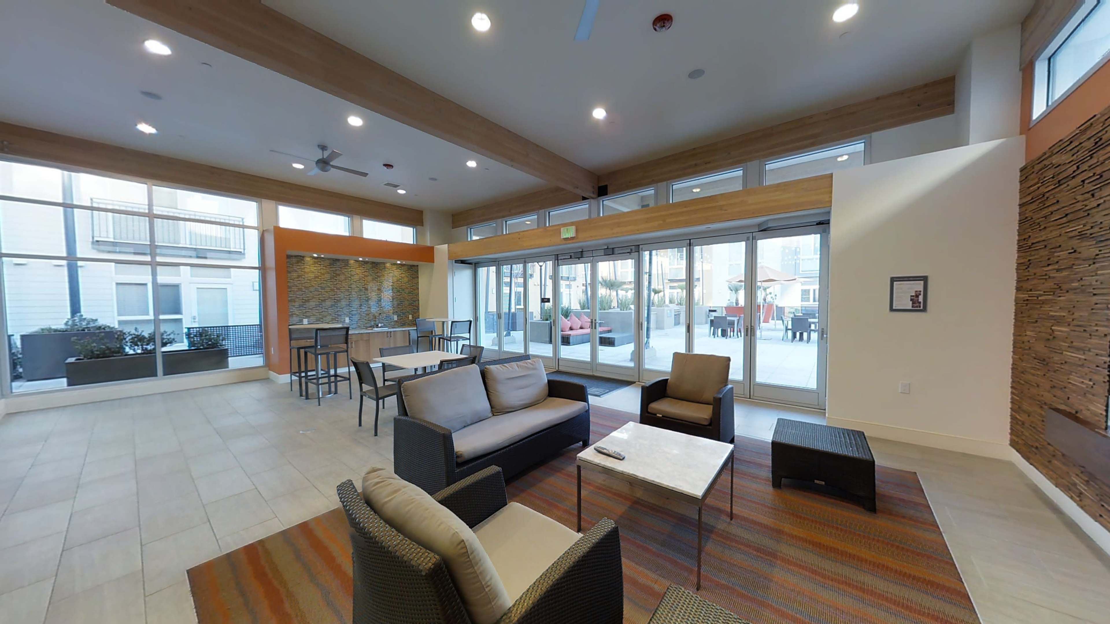 A modern lounge area with seating and large windows overlooking an outdoor space.