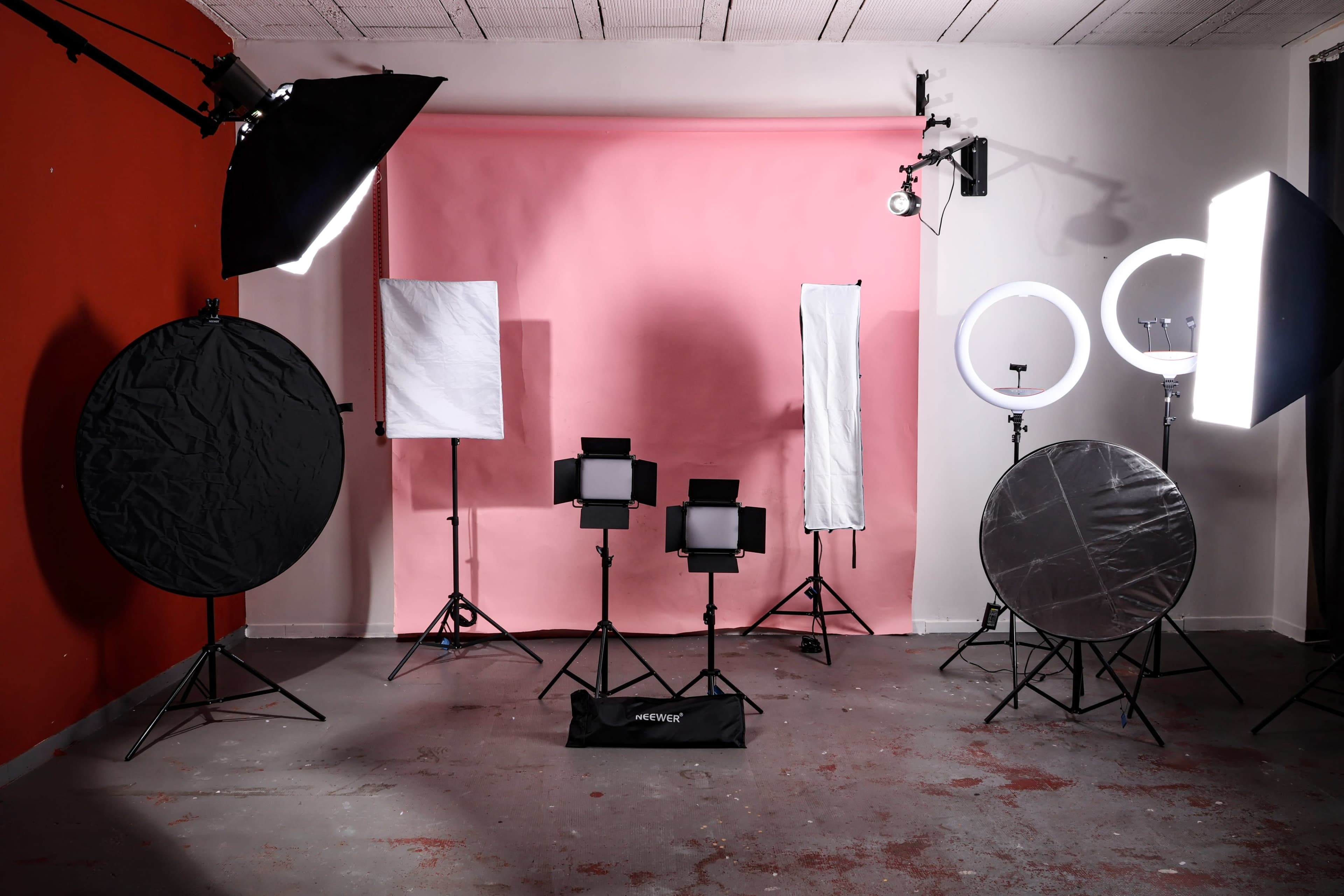 The image shows a photography studio equipped with various lighting equipment and backdrops.