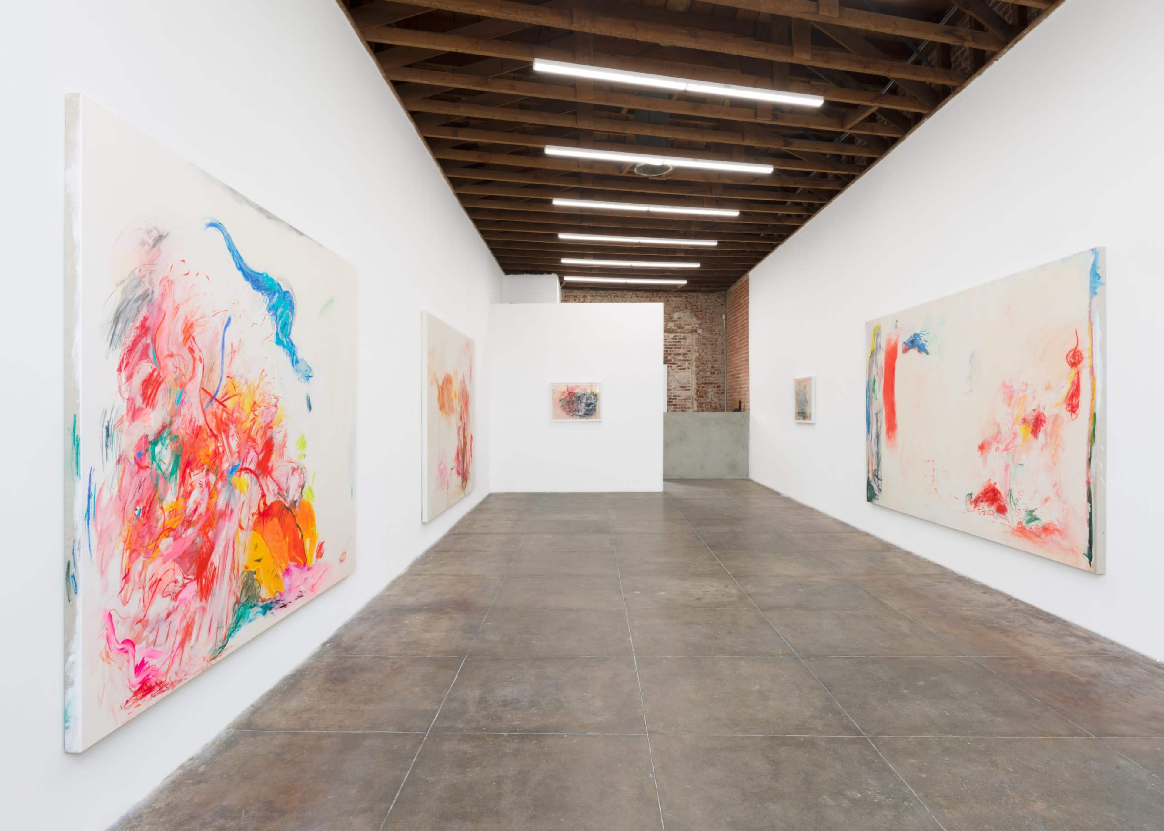 The image shows an art gallery with several large abstract paintings displayed on the white walls and a polished concrete floor.
