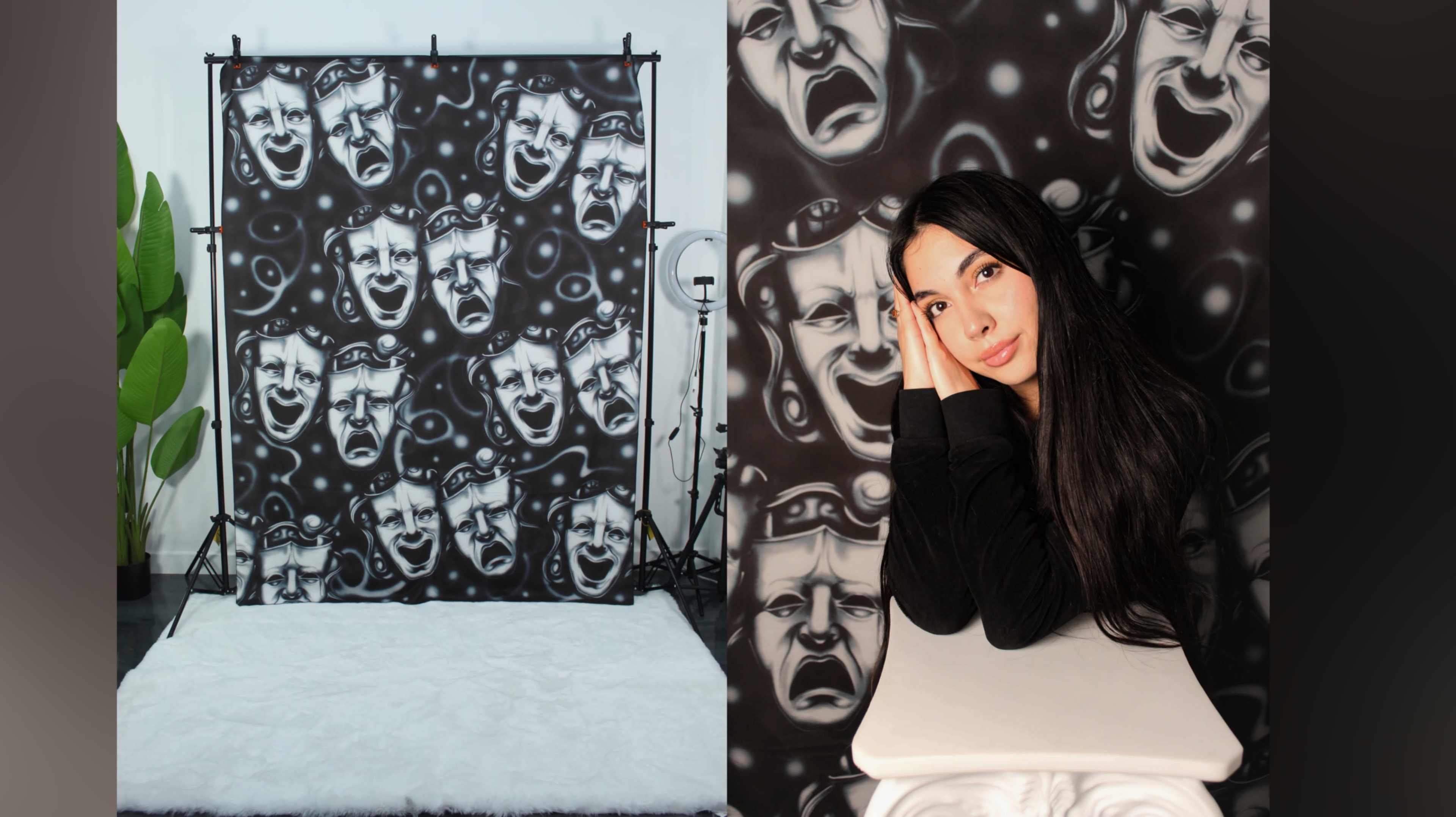 A woman with long dark hair rests her head on her hands in front of a black backdrop featuring repeated abstract faces and expressions.