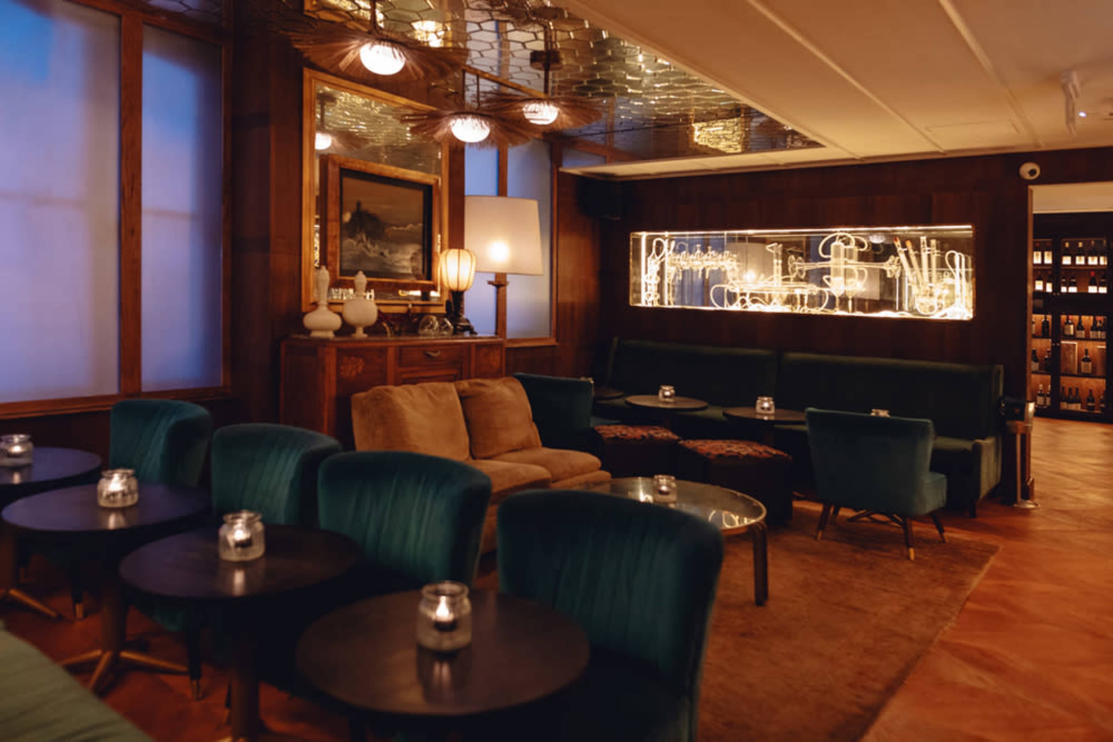 A stylish lounge area featuring plush seating, decorative lighting, and wooden accents.